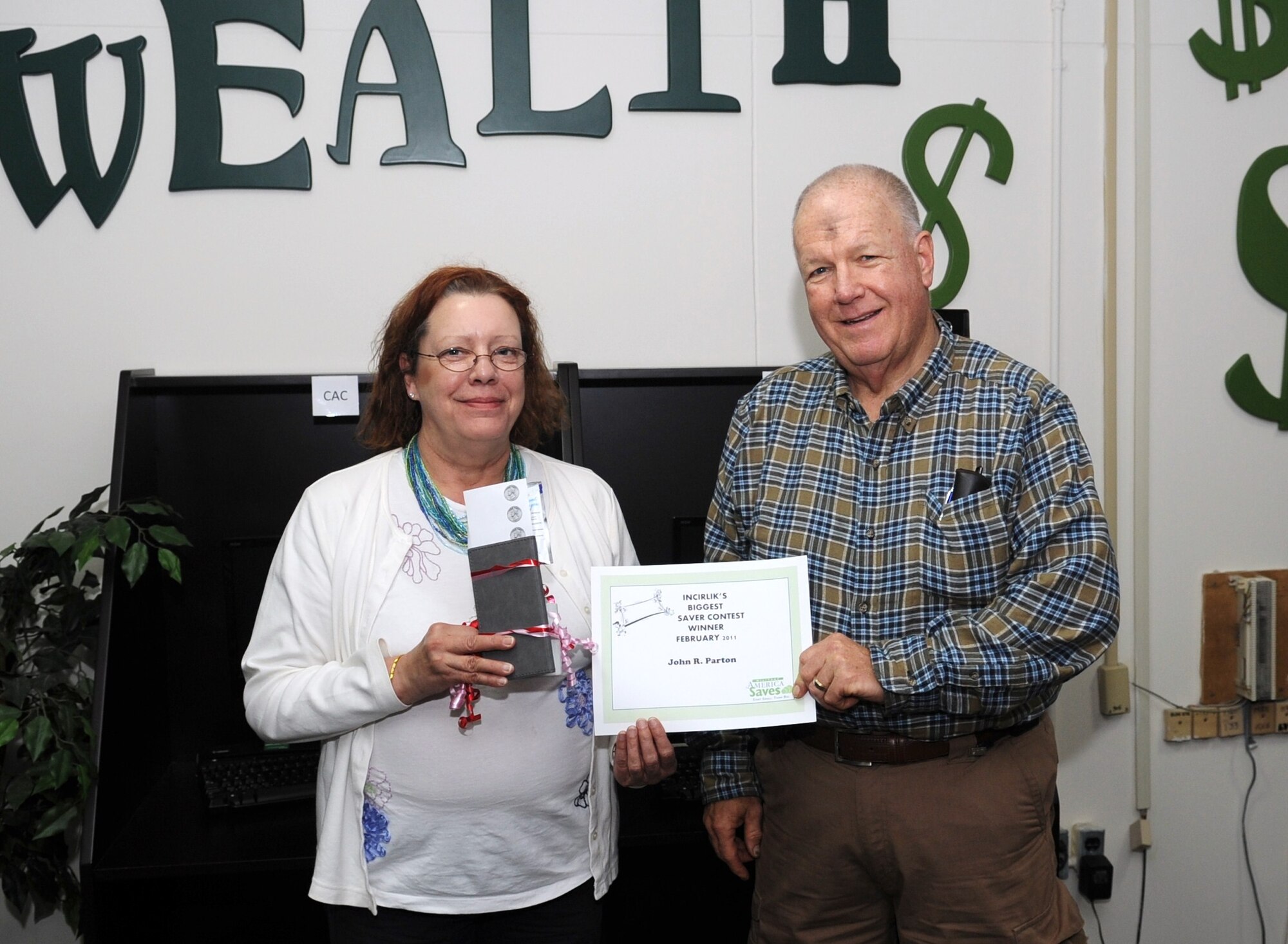Sharon Proctor, 39th Force Support Squadron community readiness consultant and the Incirlik Military Saves Campaign coordinator, presents John Parton a certificate and gift bag for being Incirlik’s Biggest Saver during the Incirlik’s Biggest Saver Competition March 9, 2011. Mr. Parton saved more than $200. Contestants were required to keep all their base receipts for the month of February.  Military Saves, which was held Feb. 20-27, is a financial readiness initiative endorsed by the Office of the Secretary of Defense, and implemented by the Air Force.  The campaign promotes healthy financial habits for Airmen and their family members by creating awareness of the importance of saving to help them reach their financial and personal goals.  (U.S. Air Force photo by Airman 1st Class Clayton Lenhardt/Released) 