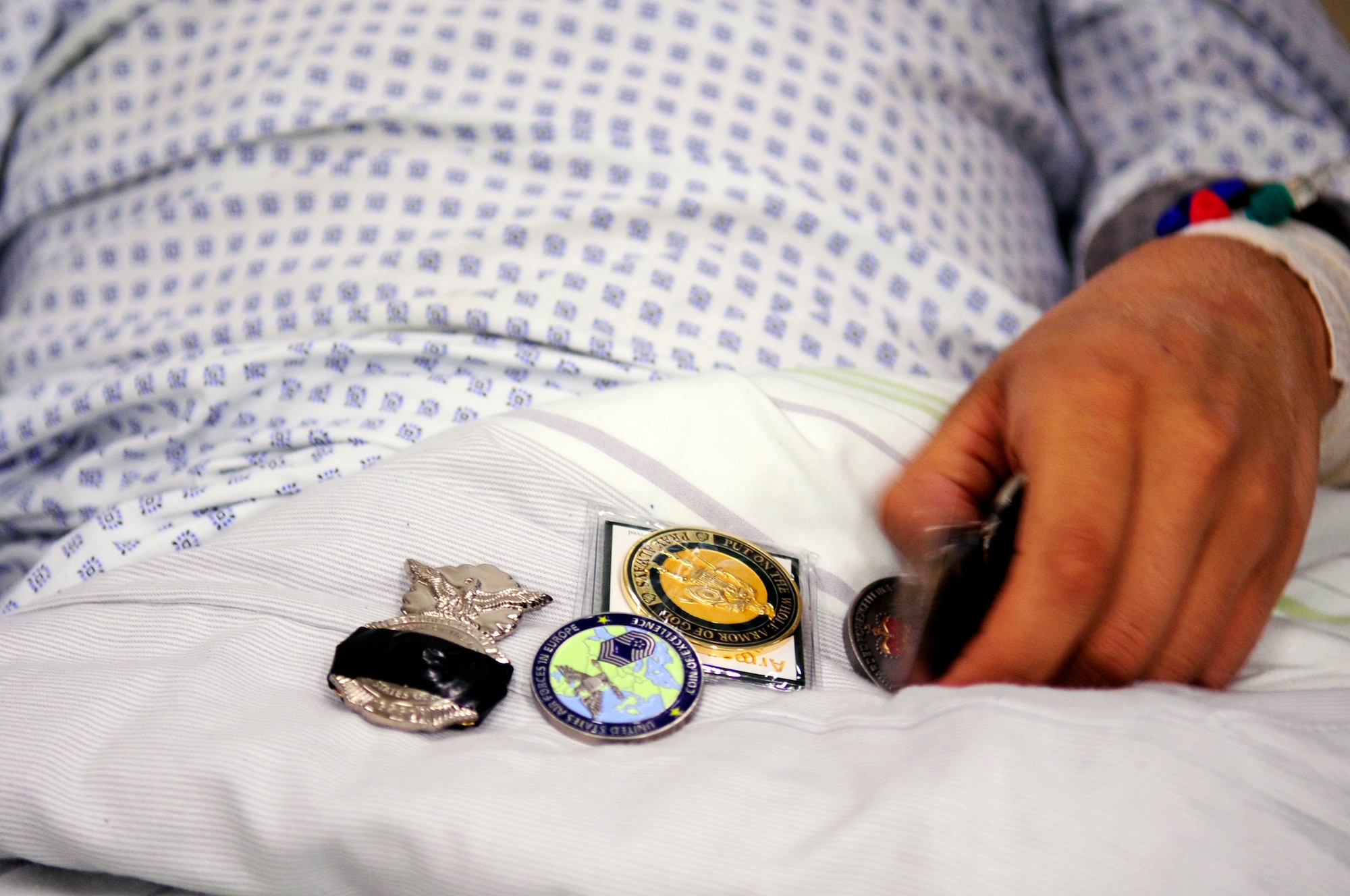 Senior Airman Edgar Veguilla, 48th Security Forces Squadron, sorts through coins he received while recovering from injuries sustained during the March 2, 2011, shooting at the Frankfurt International Airport, Germany. The RAF Lakenheath Airman was being treated at the Johann Wolfgang Goethe University Hospital in Frankfurt am Main. (U.S. Air Force photo by Tech. Sgt. Jocelyn L. Rich)