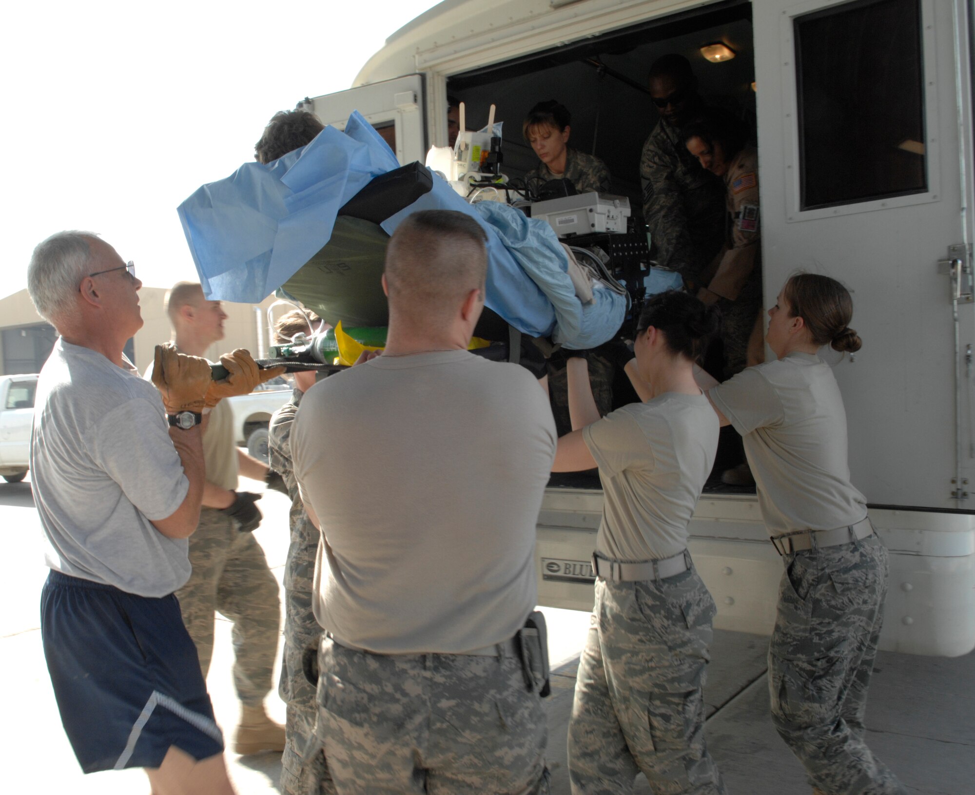 Members from the Contingency Aeromedical Staging Facility unload a patient from a bus and onto a C-17 en route to Landstuhl Medical Center, Germany. The CASF works to keep patients comfortable and cared for while they await transportation home.  (U.S. Air Force photo/Senior Airman Amber R. Kelly-Herard)
