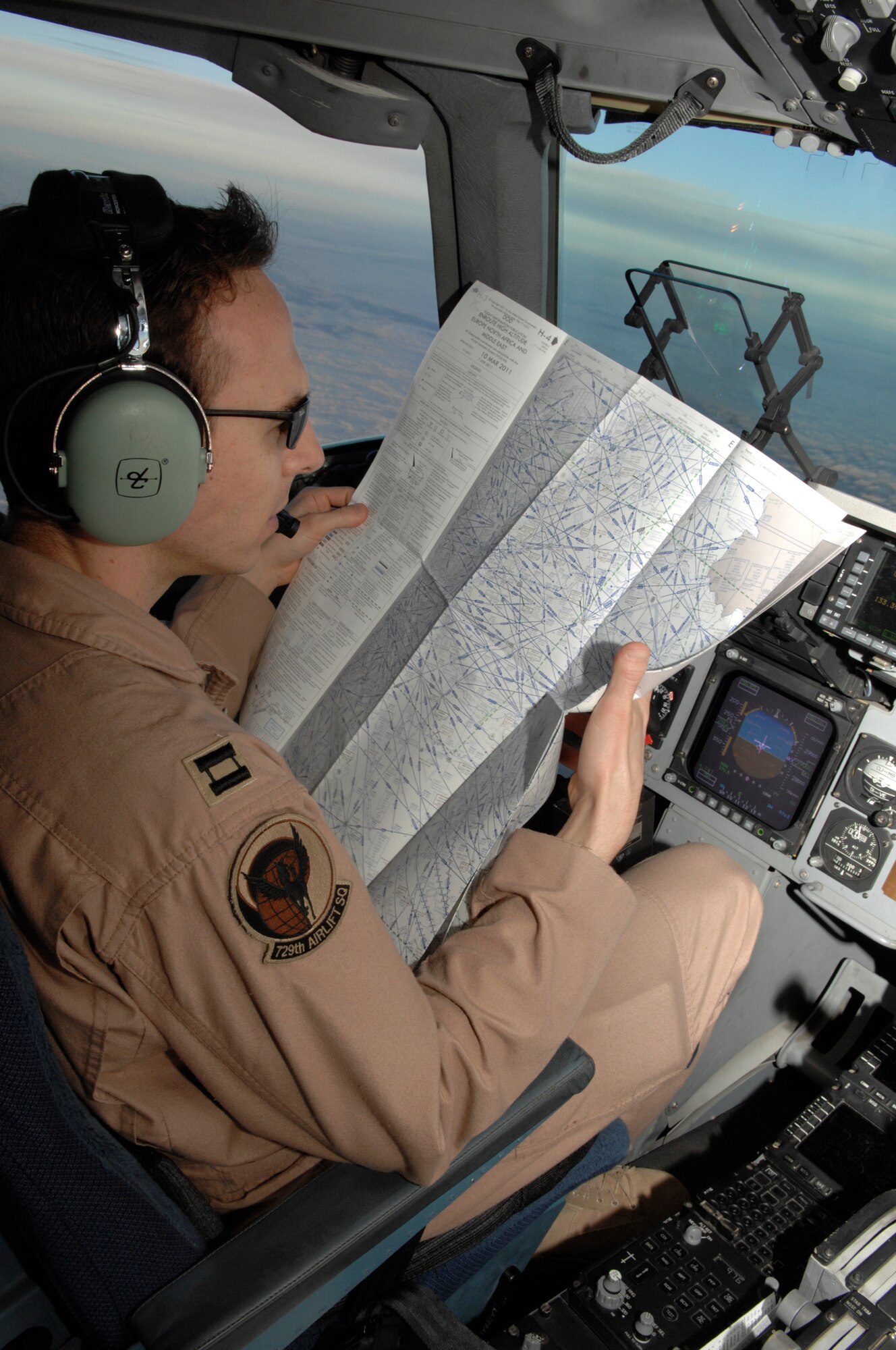 Capt. David Stanfield, 729th Airlift Squadron C-17 pilot, reads a map during a flight from Ramstein Air Base, Germany to Bagram Airfield, Afghanistan. Captain Stanfield's flying mission was to transport four trucks. (U.S. Air Force photo/Senior Airman Amber R. Kelly-Herard)