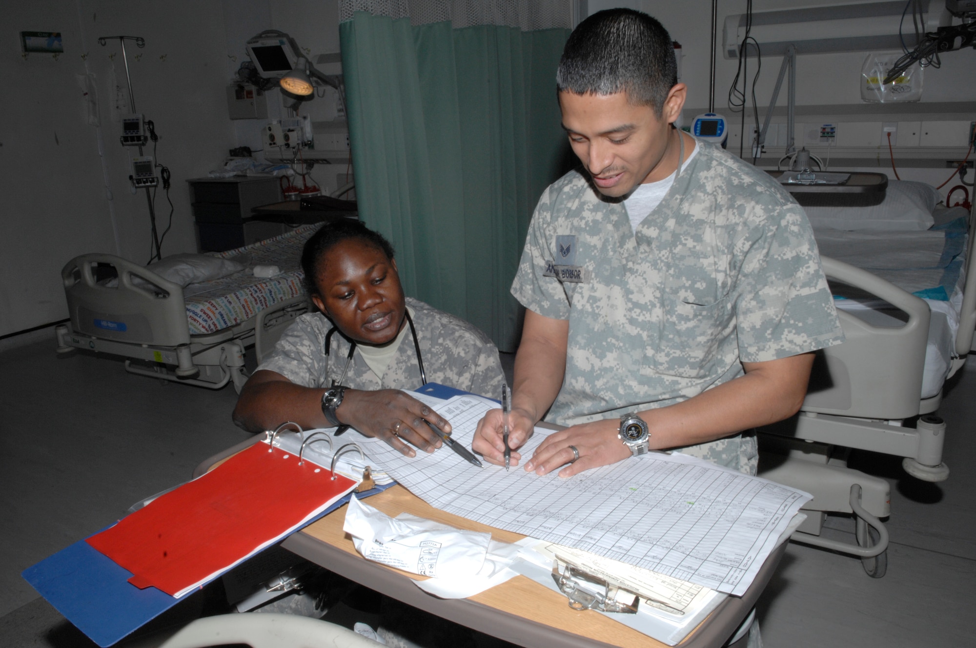 Capt. Bomidele Adetunji, Craig Joint Theater Hospital critical care nurse, and Staff Sgt. Andrade Borbor, CJTH critical care technician, review a patient’s chart in the intensive care unit. Captain Adetunji is deployed from Nellis Air Force Base, Nev., and Sergeant Borbor is deployed from Travis AFB, Calif. (U.S. Air Force photo/Senior Airman Amber R. Kelly-Herard)