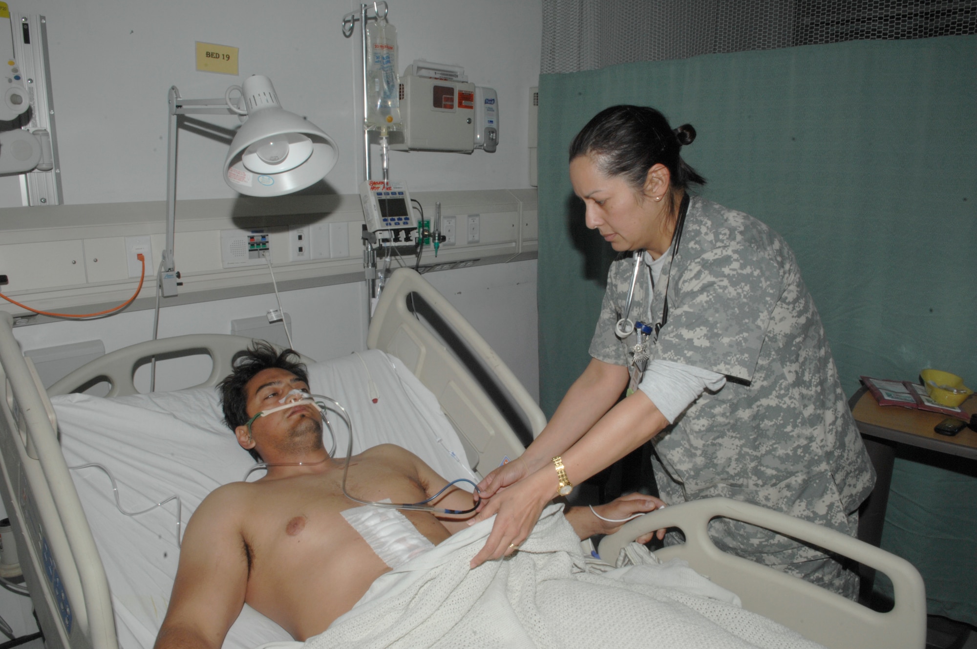 Capt. Bruni Kennon, CJTH critical care nurse, checks on Italian army Maj. Domenico Griffo while he is in the intermediate care ward. Captain Kennon is deployed from Wilford Hall Medical Center, Lackland Air Force Base, Texas.  (U.S. Air Force photo/Senior Airman Amber R. Kelly-Herard)