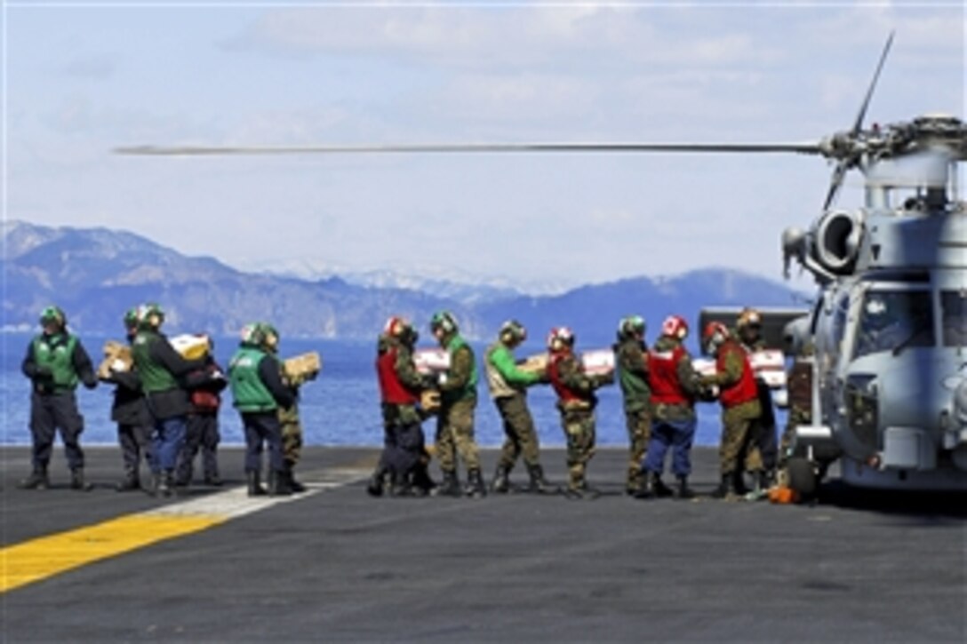 U.S. Navy sailors load food and humanitarian supplies aboard an HH-60H Seahawk helicopter aboard the aircraft carrier USS Ronald Reagan in the Pacific Ocean, March 18, 2011. The Ronald Reagan is off the coast of Japan providing humanitarian assistance to Japan to support Operation Tomodachi after the recent 8.9-magnitude earthquake and tsunami. The sailors are assigned to Helicopter Anti-Submarine Squadron 4.