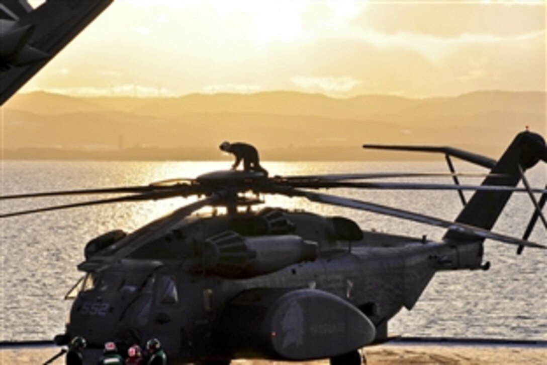 U.S. Navy Senior Chief Petty Officer Francisco Garcia makes one final check on the propellers of an HM-53E helicopter before it leaves the flight deck of USS Tortuga off Ominato, Japan, March 18, 2011. The Tortuga is in the U. S. 7th Fleet area of operations supporting earthquake and tsunami relief efforts. 