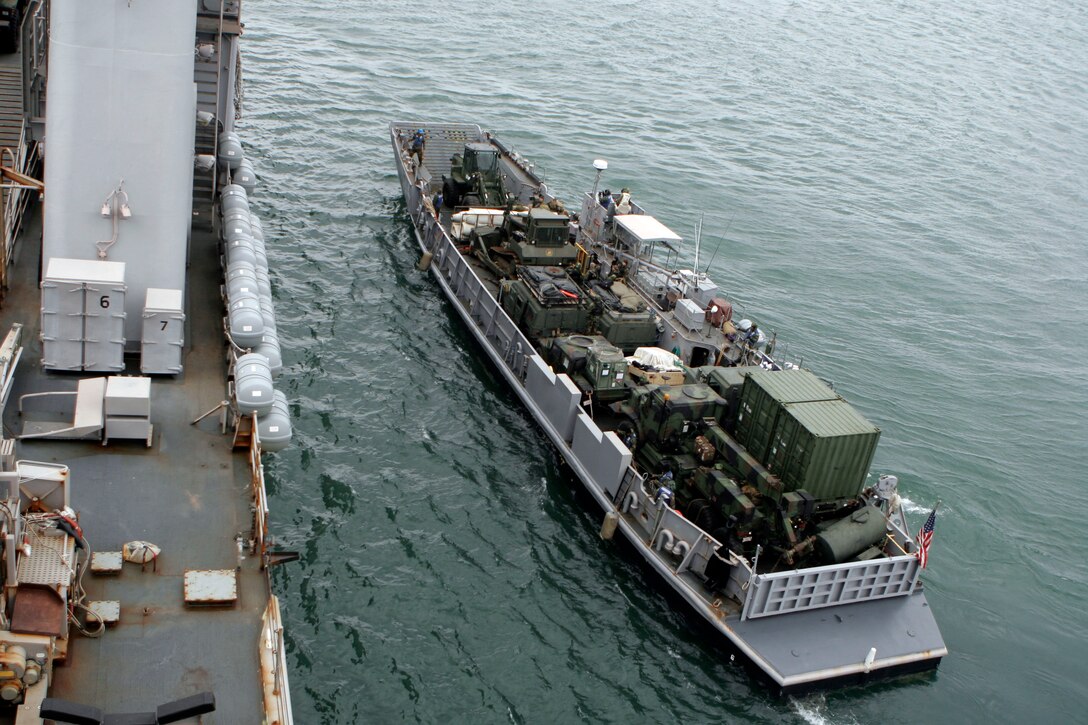 A landing craft utility, carrying vehicles and equipment from the 31st Marine Expeditionary Unit, maneuvers next to the USS Harpers Ferry (LSD 49), March 19. Navy and Marine Corps involvement is part of a larger U.S. government response, coordinated through the U.S. Department of State, after a 9.0 earthquake and subsequent tsunami struck Japan causing widespread damage. As part of Operation Tomodachi, the 31st MEU is ready to support our Japanese partners and to provide assistance when called upon.