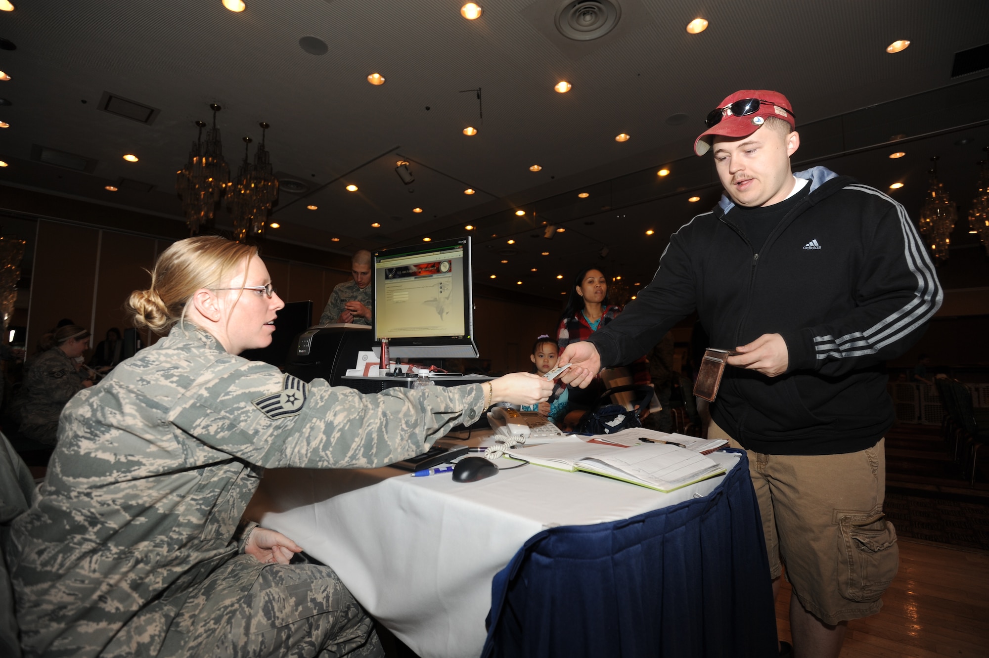 MISAWA AIR BASE, Japan -- Staff Sgt. Daniel Clark, 35 Maintenance Squadron, completes a power of attorney, with the help of SSgt Lenaha Kidd from the 35th Fighter Wing Judge Advocate Office, at the Department of State-approved voluntary departure of family members processing line March 19. Sergeant Clark?s family will temporarily relocate to the continental United States while restoration efforts continue in Japan after the 9.0 earthquake and resulting tsunami Mar. 11. (U.S. Air Force photo by Staff Sgt. April Quintanilla\Released)
