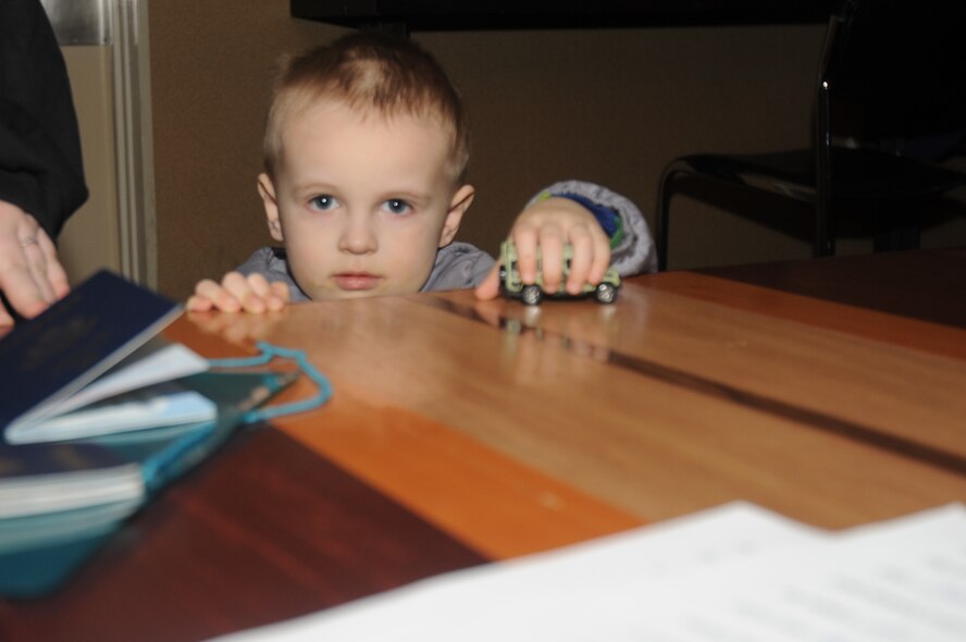 MISAWA AIR BASE, Japan -- Three-year-old David Finstuen, son of Senior Airman Kevin Finstuen, 35th communications Squadron, accompanies his father while completing paperwork needed for his family to take advantage of the Department of State-approved voluntary departure of family members March 19. Family members will temporarily relocate to the continental United States while restoration efforts continue in Japan after the 9.0 earthquake and resulting tsunami Mar. 11. (U.S. Air Force photo by Staff Sgt. April Quintanilla\Released)