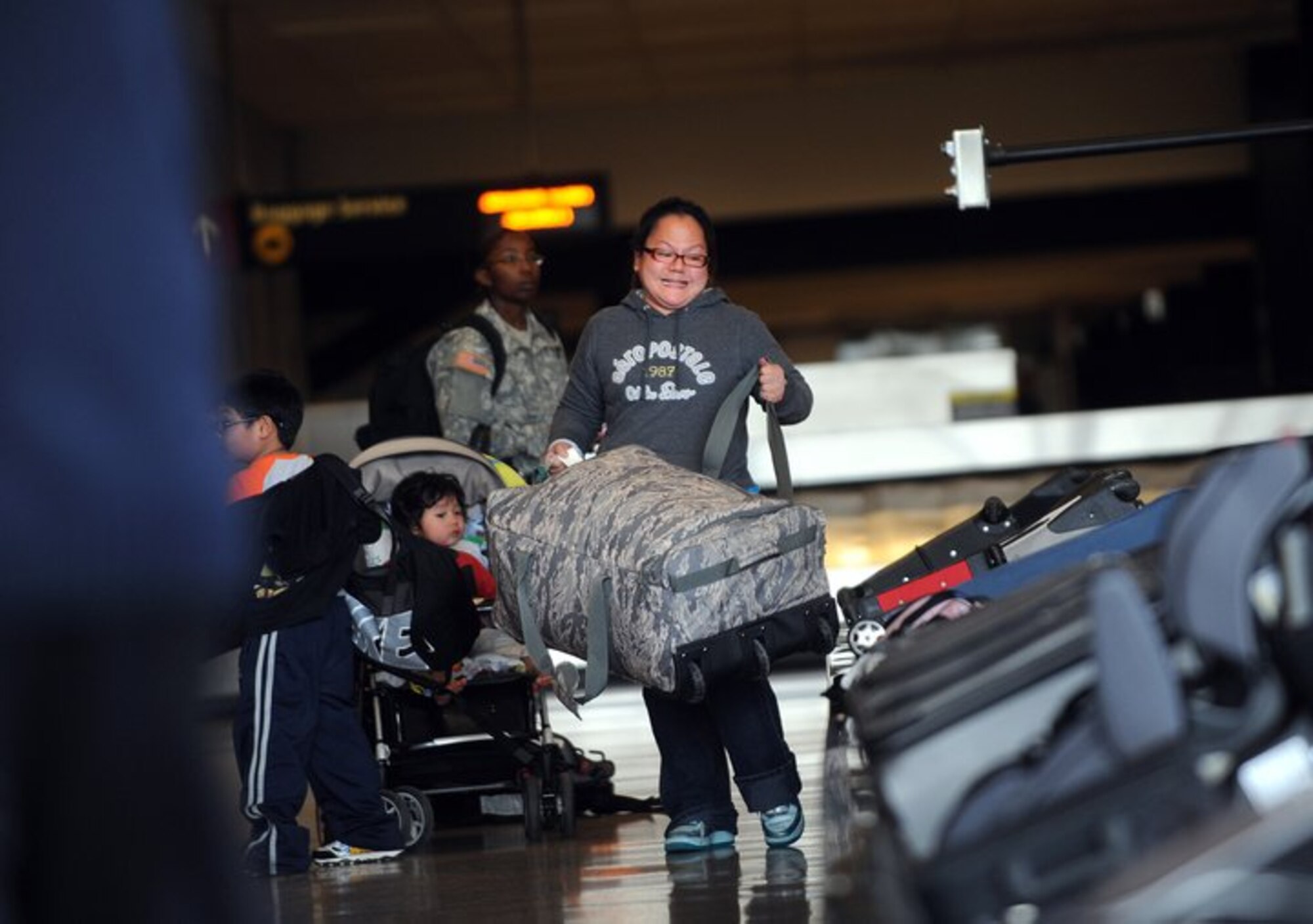 A woman retrieves a bag from a carousel at the Seattle-Tacoma International Airport March 19, 2011. About 240 servicemembers and their families landed at Sea-Tac in what is to be the first wave of more than 6,000 returning from Japan.