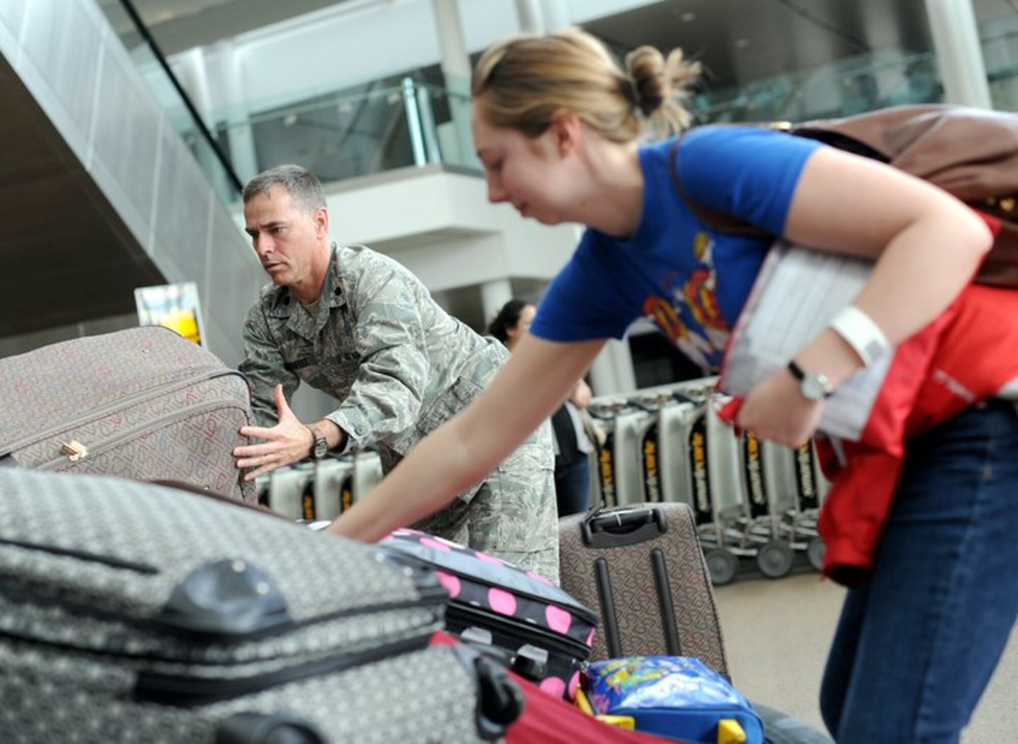 Lt. Col. Michael Husfelt, 627th Air Base Group wing chaplain, helps unload baggage from a carousel March 19, 2011 at Seattle-Tacoma International Airport. About 240 servicemembers and their families landed at Sea-Tac in what is to be the first wave of more than 6,000 returning from Japan.
