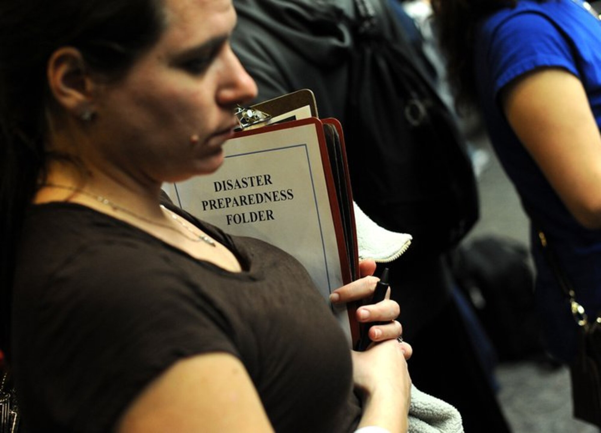 A woman clutches a disaster preparedness folder while waiting at the Seattle-Tacoma International Airport USO March 19, 2011. About 240 servicemembers and their families landed at Sea-Tac in what is to be the first wave of more than 6,000 military personnel and families coming in from Japan.
