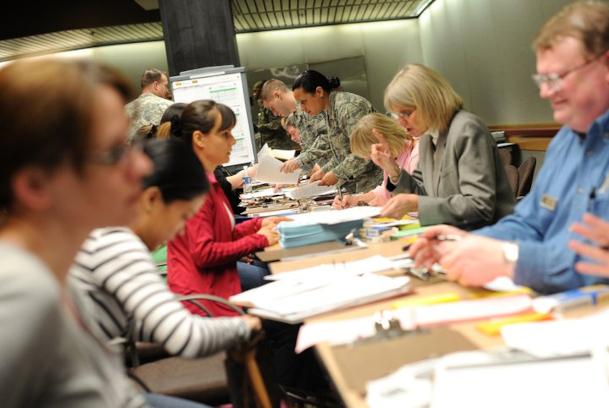 Military personnel help military family members from Japan fill out paperwork at Seattle-Tacoma International Airport March 19, 2011. About 240 servicemembers and their families landed at Sea-Tac in what is to be the first wave of more than 6,000 evacuees.