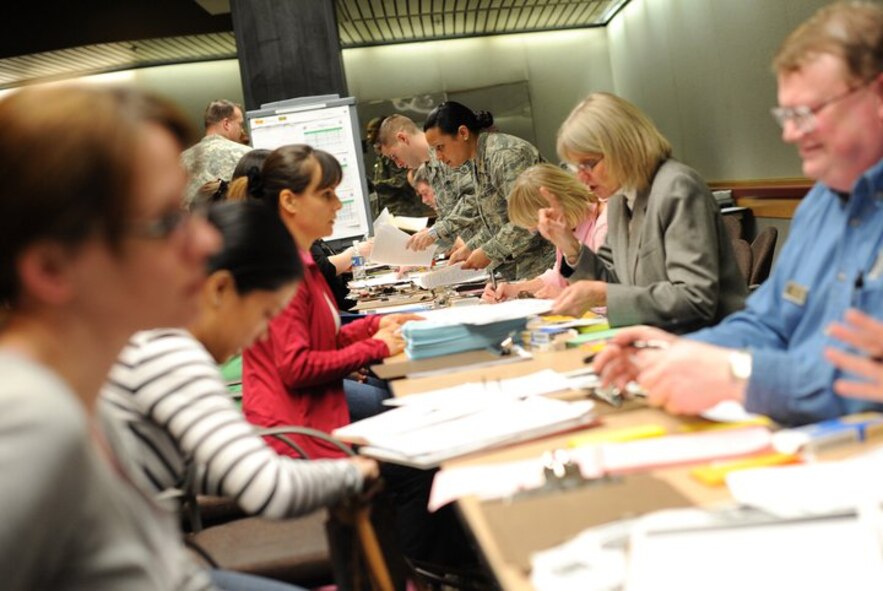 Military personnel help military family members from Japan fill out paperwork at Seattle-Tacoma (Wash.) International Airport on March 19, 2011. More than 230 Department of Defense personnel and family members landed at Sea-Tac in what is to be the first flight of many arriving from Japan.  (U.S. Air Force Photo)