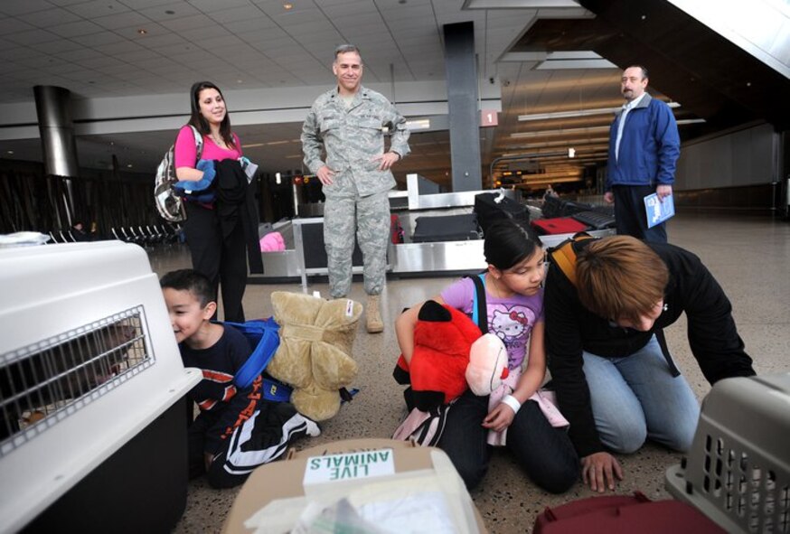 Caleb Velazquez, 5, left, and his sister Aubri, 8, and friend Jess Alexander check on Alexander's dogs as Monica Peck and Lt. Col. Michael Husfelt, 627th Air Base Group chaplain, look on March 19, 2011, at Seattle-Tacoma (Wash.) International Airport. More than 230 Department of Defense personnel and family members landed at Sea-Tac in what is to be the first flight of many arriving from Japan.  (U.S. Air Force Photo)