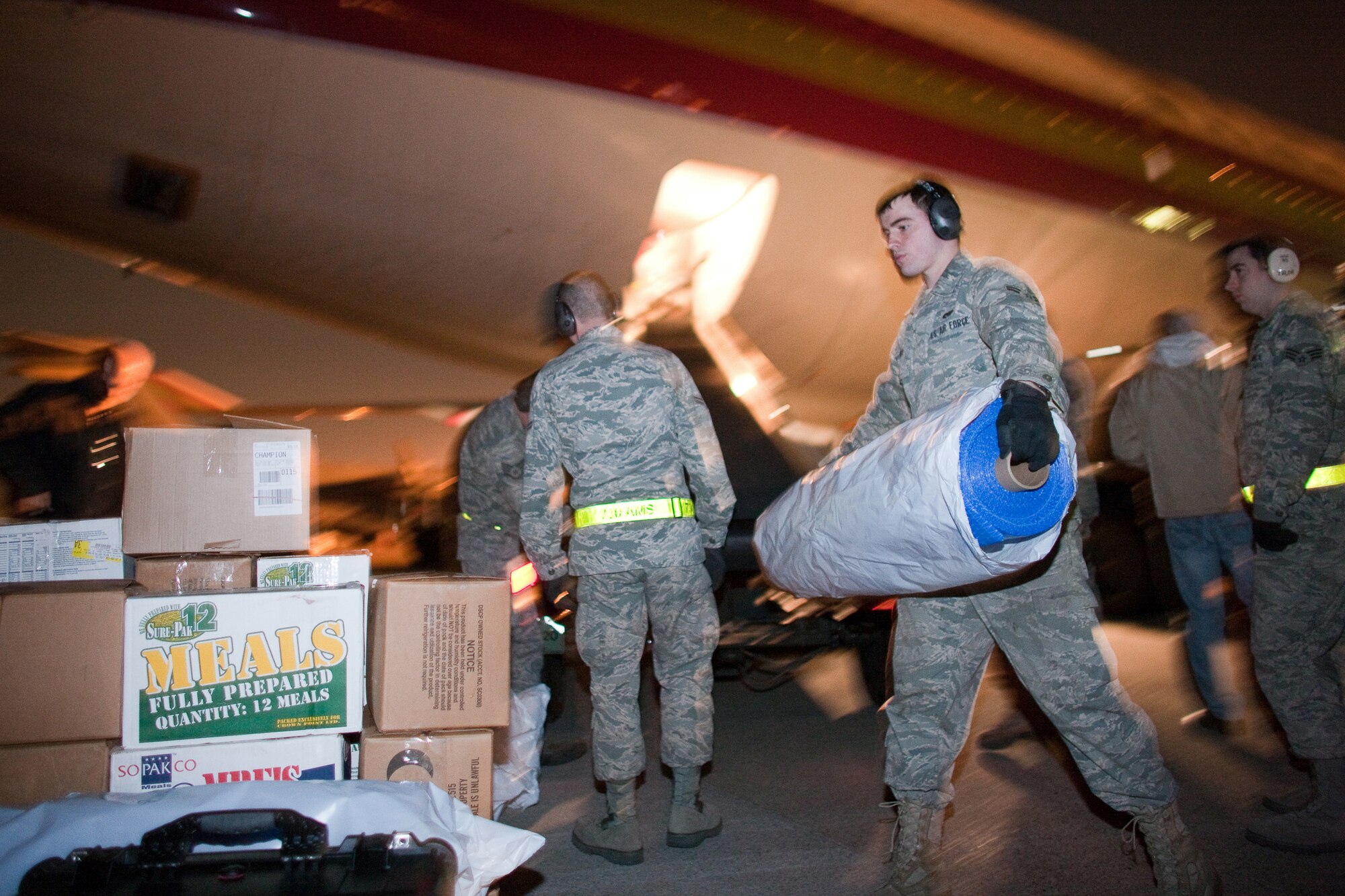 YOKOTA AIR BASE, Japan -- Airman 1st Class Justin Smith, 730th Air Mobility Squadron, unloads relief supplies here March 19. An international charter aircraft delivered 95 tons of blankets, plastic sheeting, hygiene supplies, soap and jerry cans to assist with earthquake and tsunami relief efforts. (U.S. Air Force photo/Osakabe Yasuo)