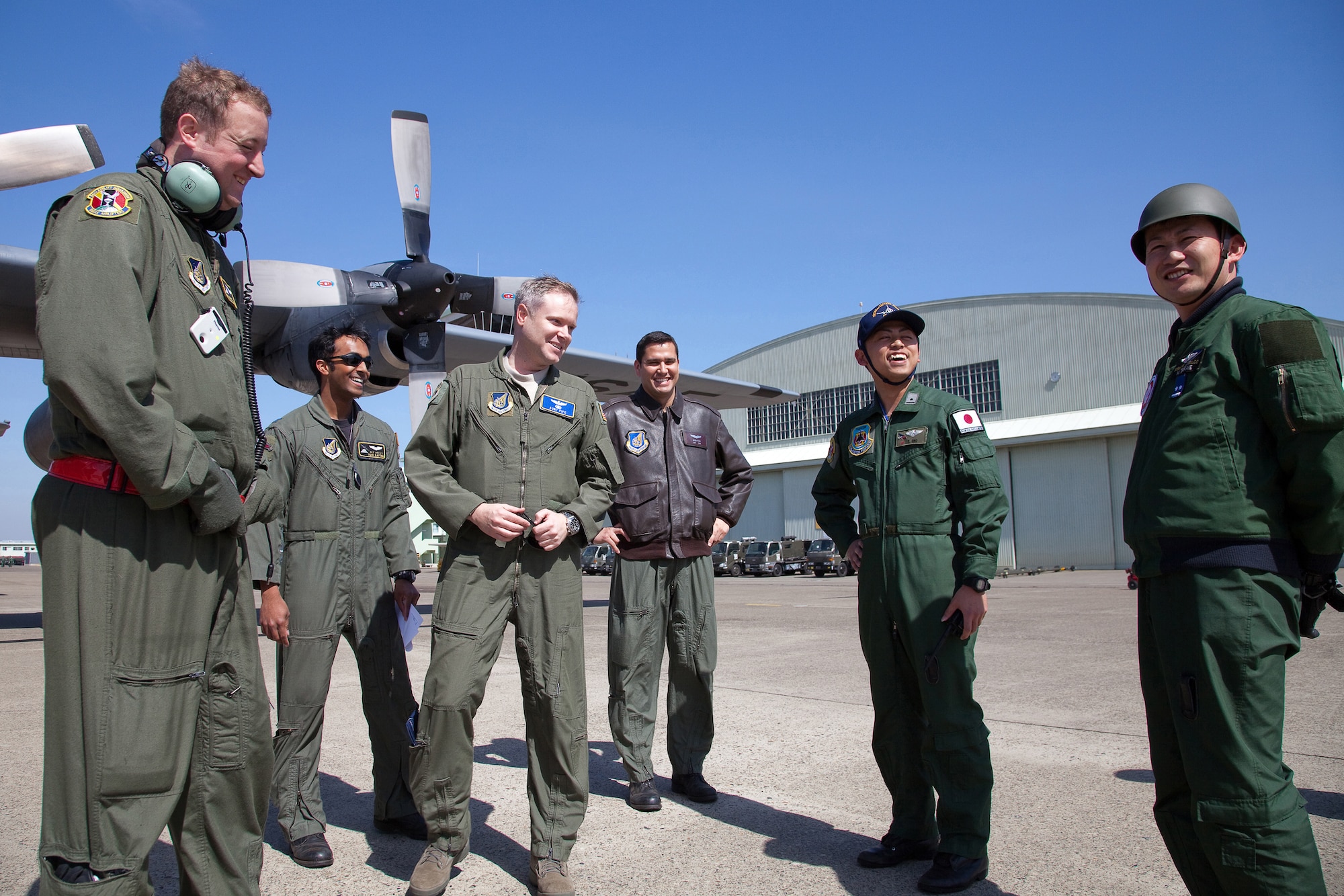 HYAKURI AIR BASE, Japan -- Airmen from the 36th Airlift Squadron and Japanese Air Self-Defense Force members talk after delivering seven pallets of boron here March 19. Japanese forces will use the boron to aid stabilization efforts at the Fukushima Daiichi nuclear plant.  (U.S. Air Force photo/Osakabe Yasuo)
