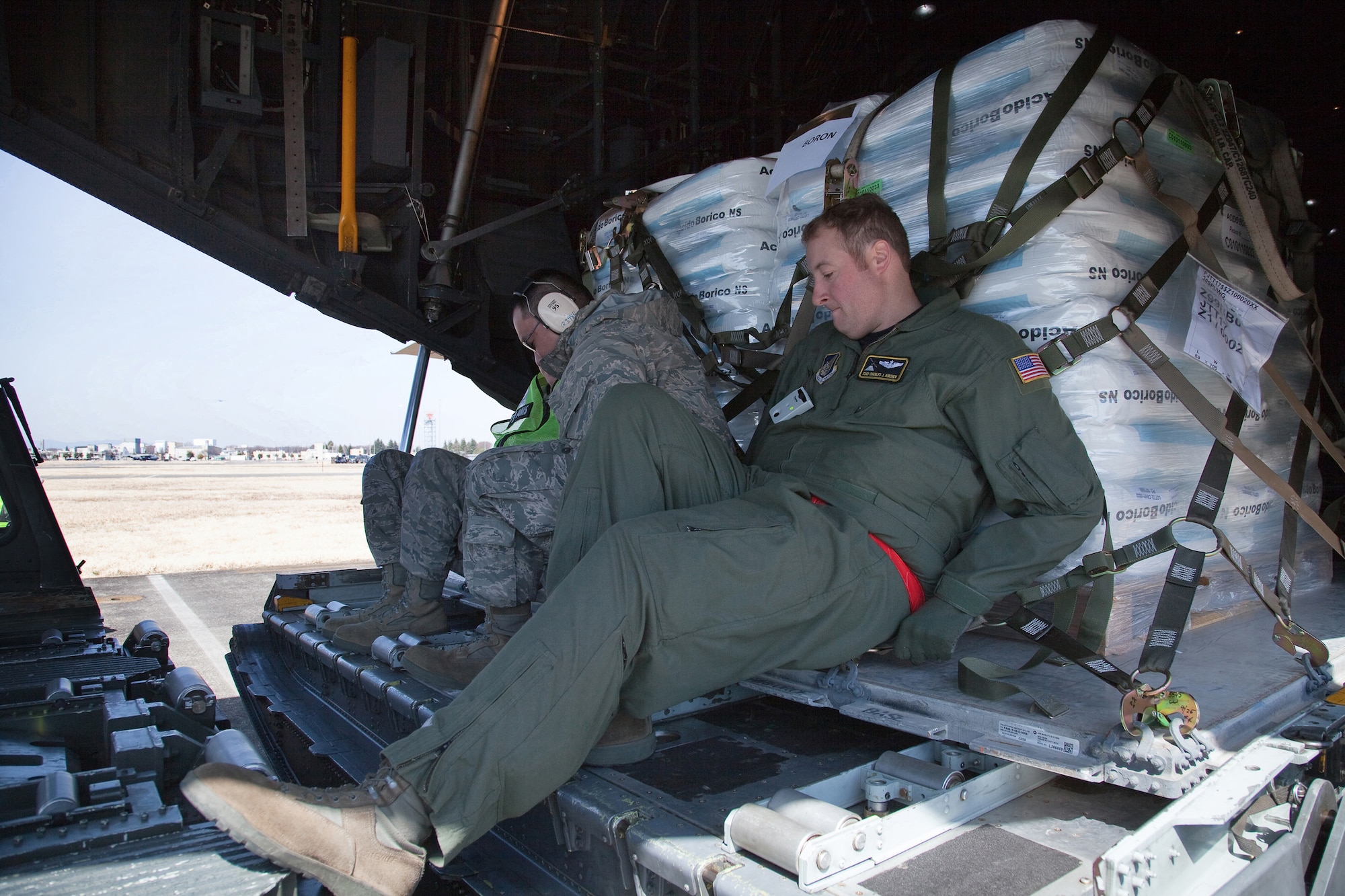 YOKOTA AIR BASE, Japan -- Staff Sgt. Charles Kirchen, 36th Airlift Squadron, uploads pallets of boron onto a C-130 Hercules, before departing for Hyakuri Air Base March 19. Japanese forces will use the boron to help stabilization efforts at the Fukushima Daiichi nuclear plant. (U.S. Air Force photo/Osakabe Yasuo)