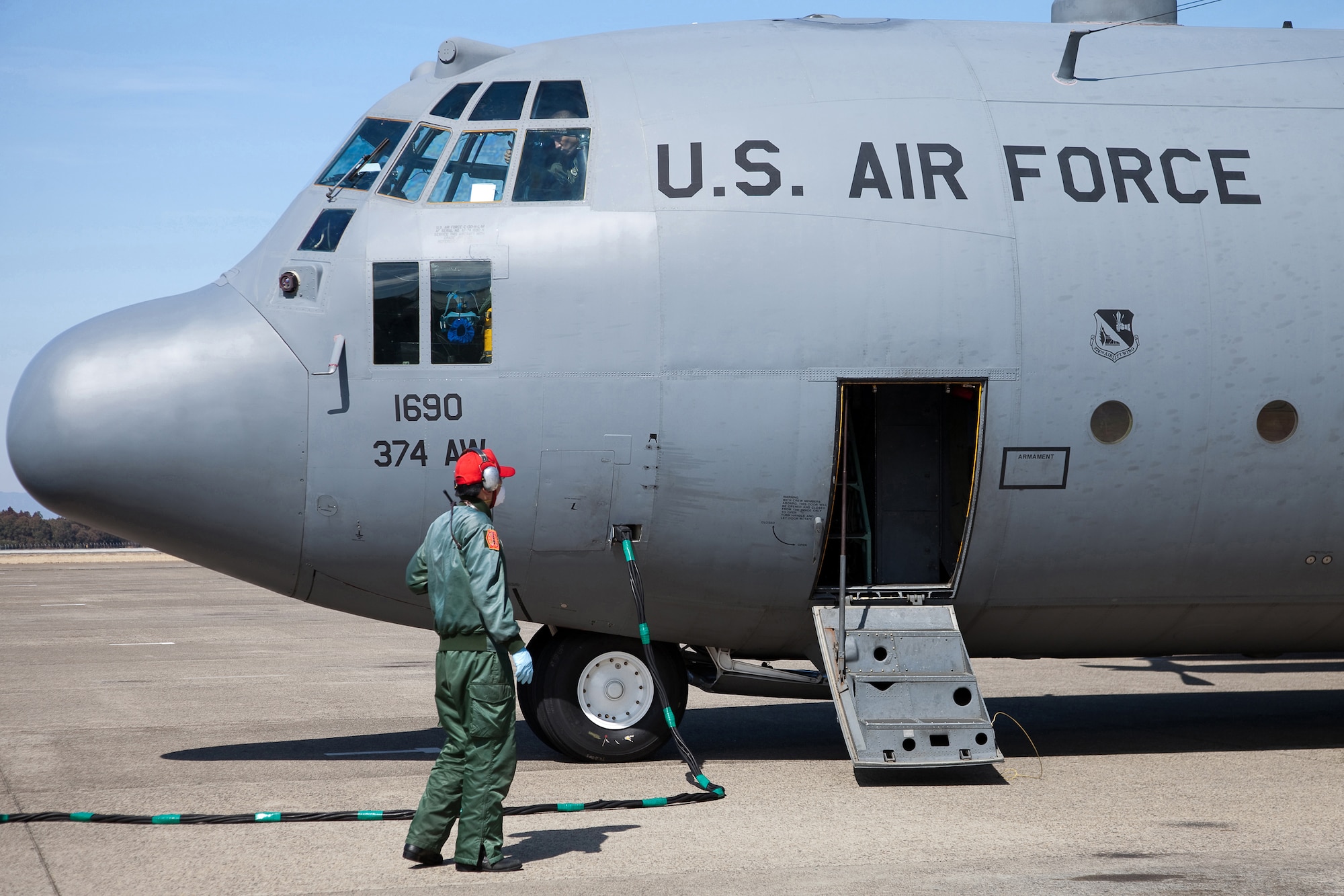 HYAKURI AIR BASE, Japan -- Members from Japan Air Self-Defense Force provides power for a US Air Force C-130 Hercules after unloading seven boron pallets here March 19. Aircrews from the 36th Airlift Squadron delivered the boron to help stabilization efforts at the Fukushima Daiichi nuclear plant. (U.S. Air Force photo/Osakabe Yasuo)
