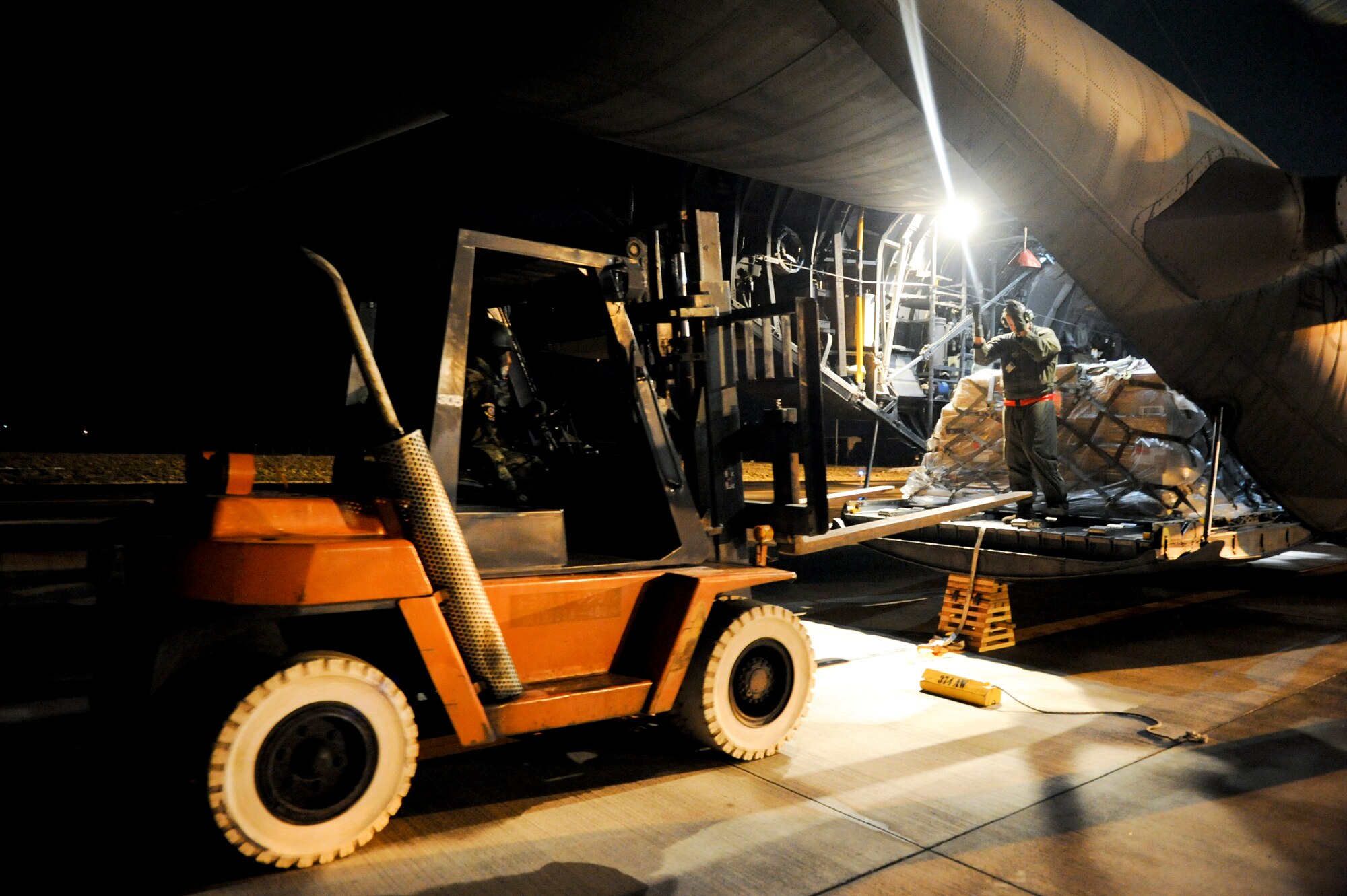HANAMAKI, Japan -- Staff Sgt. Charles Kirchen, 36th Airlift Squadron, directs a forklift towards a C-130H Hercules here March 19. Medical supplies were flown out to Sendai and Hanamaki Airport to be distributed to local hospitals and evacuation centers as part of Operation Tomodachi.   (U.S. Air Force photo/Staff Sgt. Jonathan Steffen)