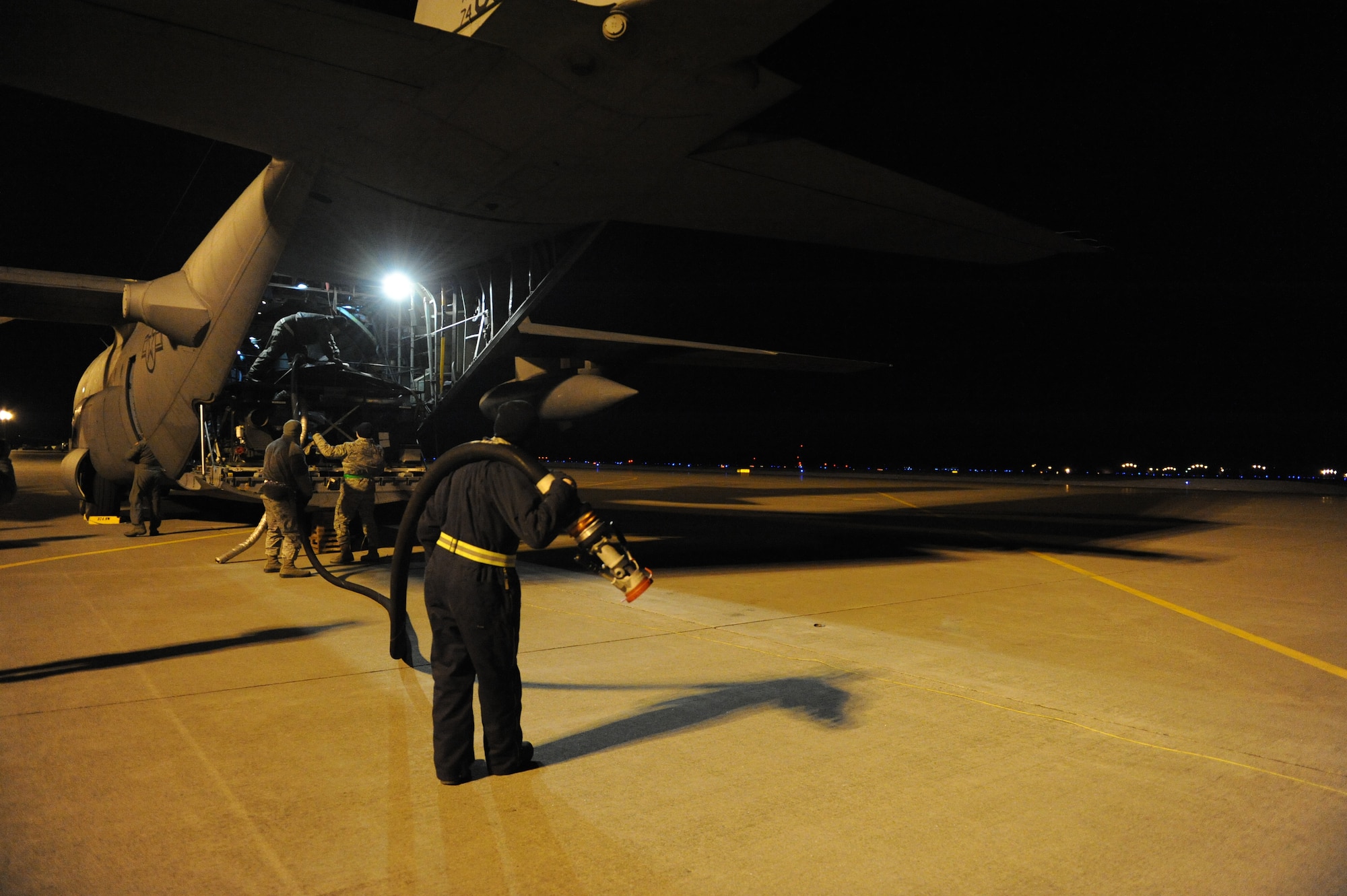 MISAWA AIR BASE, Japan–Members of a U.S. Air Force C-130 Hercules roll out fuel hoses as they prepare to fill fuel trucks here Mar 18. The fuel was flown in from Yokota Air Base and is being provided in support of Operation Tomadachi. (U.S. Air Force Photo/Tech. Sgt. Russell J. McBride)