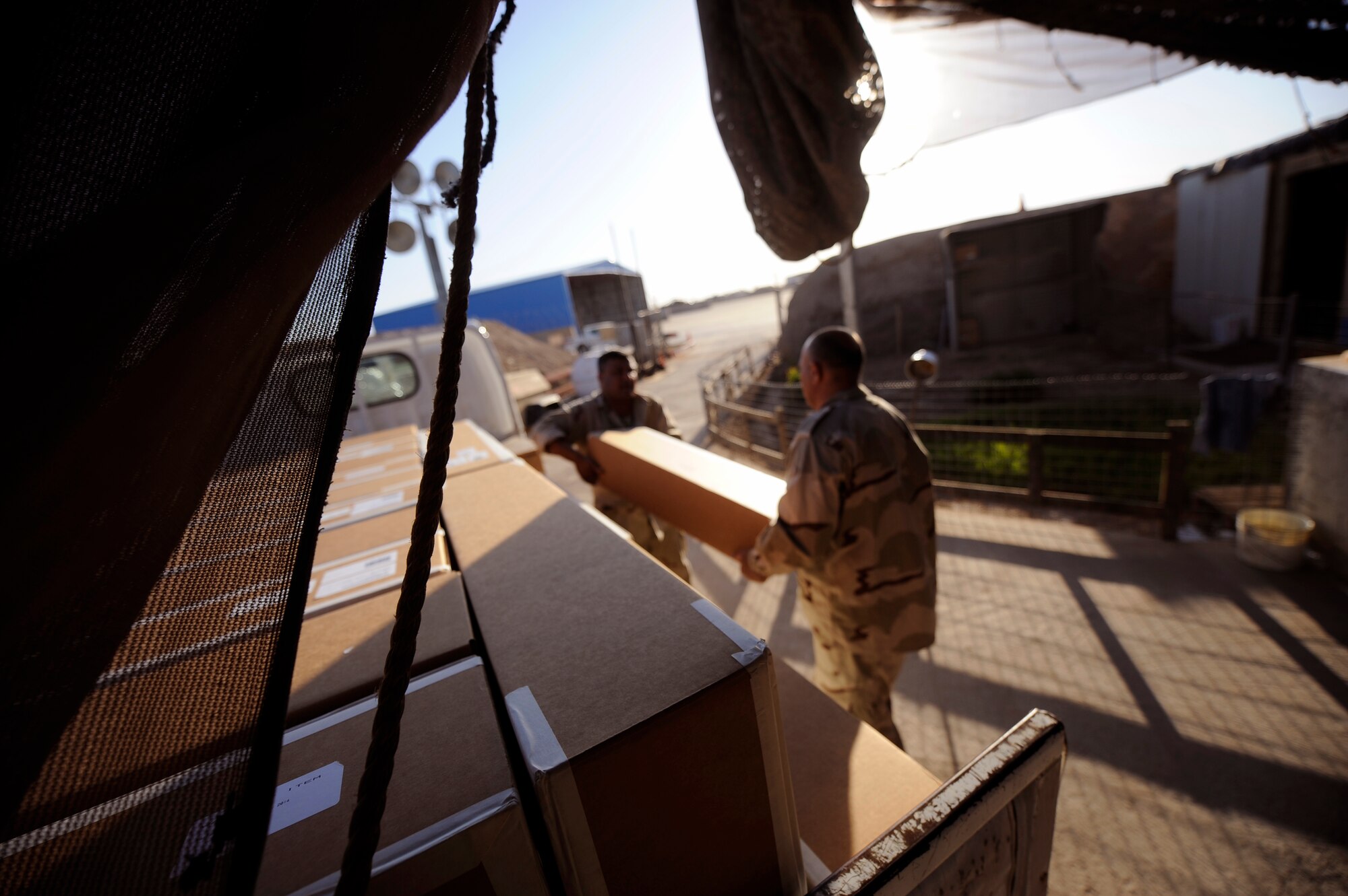 CAMP TAJI, Iraq -- Iraqi Army Aviation Command soldiers, or 'jundees,' unload M240 weapons before storing them in the flightline weapons armory March 14. A half dozen 721st Air Expeditionary Advisory Squadron advisors comprised of ammo, weapons and maintenance specialists helped complete a mission to deliver nearly 30 machine guns that will eventually be mounted to Iraqi Mi-171E aircraft used for various missions throughout the country. (U.S. Air Force/Tech. Sgt. Jason Lake)