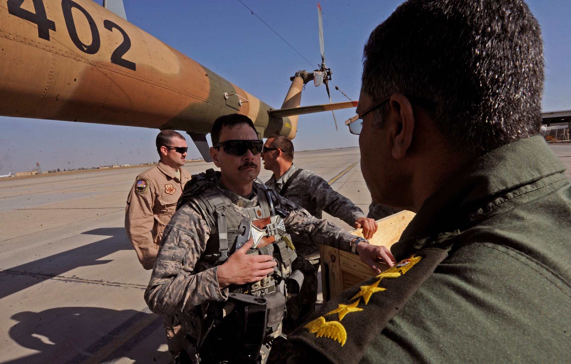 BAGHDAD -- Maj. Claudio Covacci, 721st Air Expeditionary Advisory Squadron maintenance officer, talks with Iraqi Army Aviation Command leadership during a mission to deliver M240 machine guns from Baghdad to Camp Taji March 14. A half dozen 721st Air Expeditionary Advisory Squadron advisors comprised of ammo, weapons and maintenance specialists helped complete a mission to deliver nearly 30 machine guns that will eventually be mounted to Iraqi  Mi-171E aircraft used for various missions throughout the country. (U.S. Air Force/Tech. Sgt. Jason Lake)