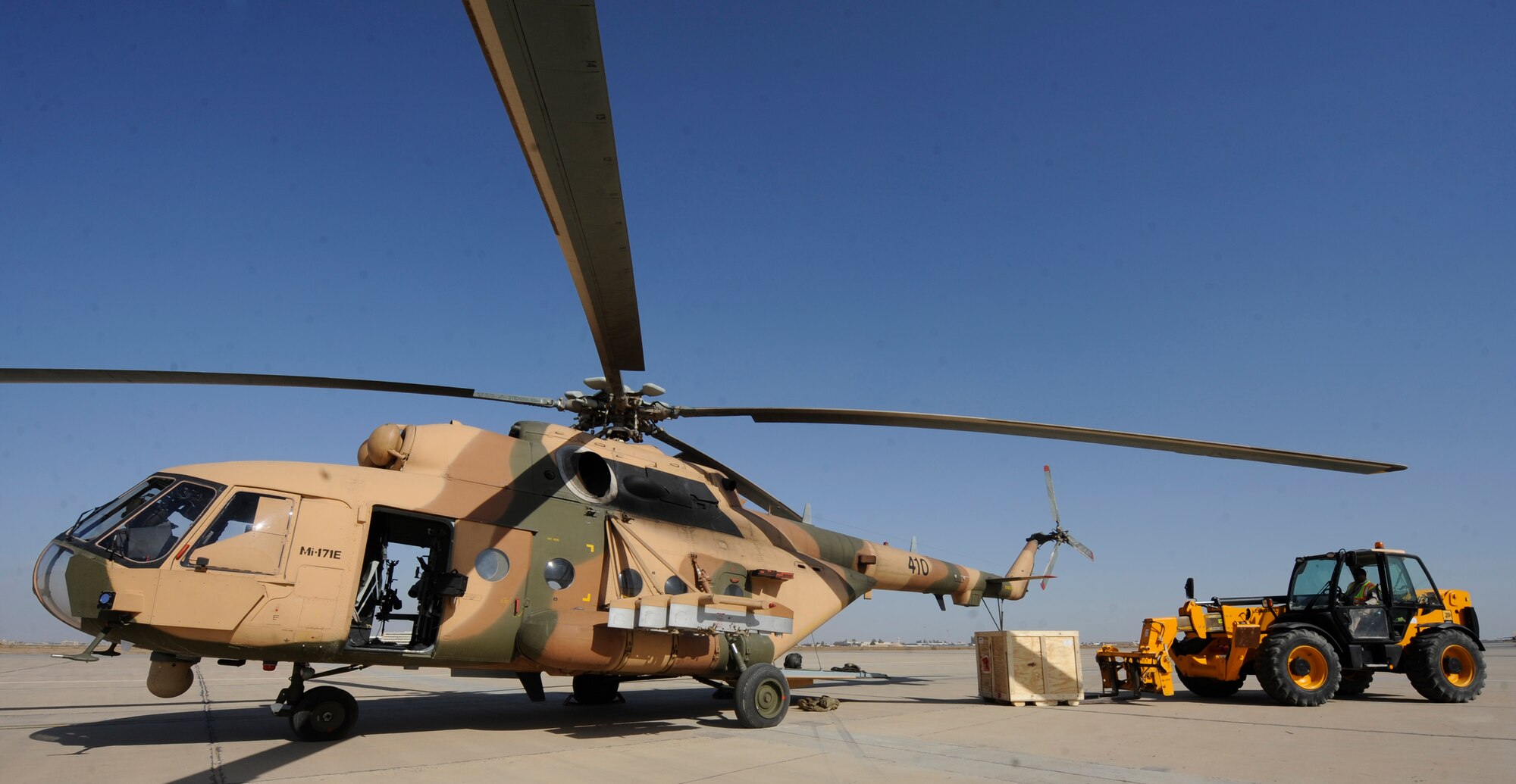 BAGHDAD -- A U.S. contractor moves a crate of  M240 weapons so Iraqi Army Aviation Command soldiers can load them onto two Mi-171 multi-mission helicopters March 14. A half dozen 721st Air Expeditionary Advisory Squadron advisors helped deliver nearly 30 machine guns that will eventually be mounted to Iraqi Mi-171E aircraft to be used for various missions throughout the country. (U.S. Air Force/Tech. Sgt. Jason Lake)