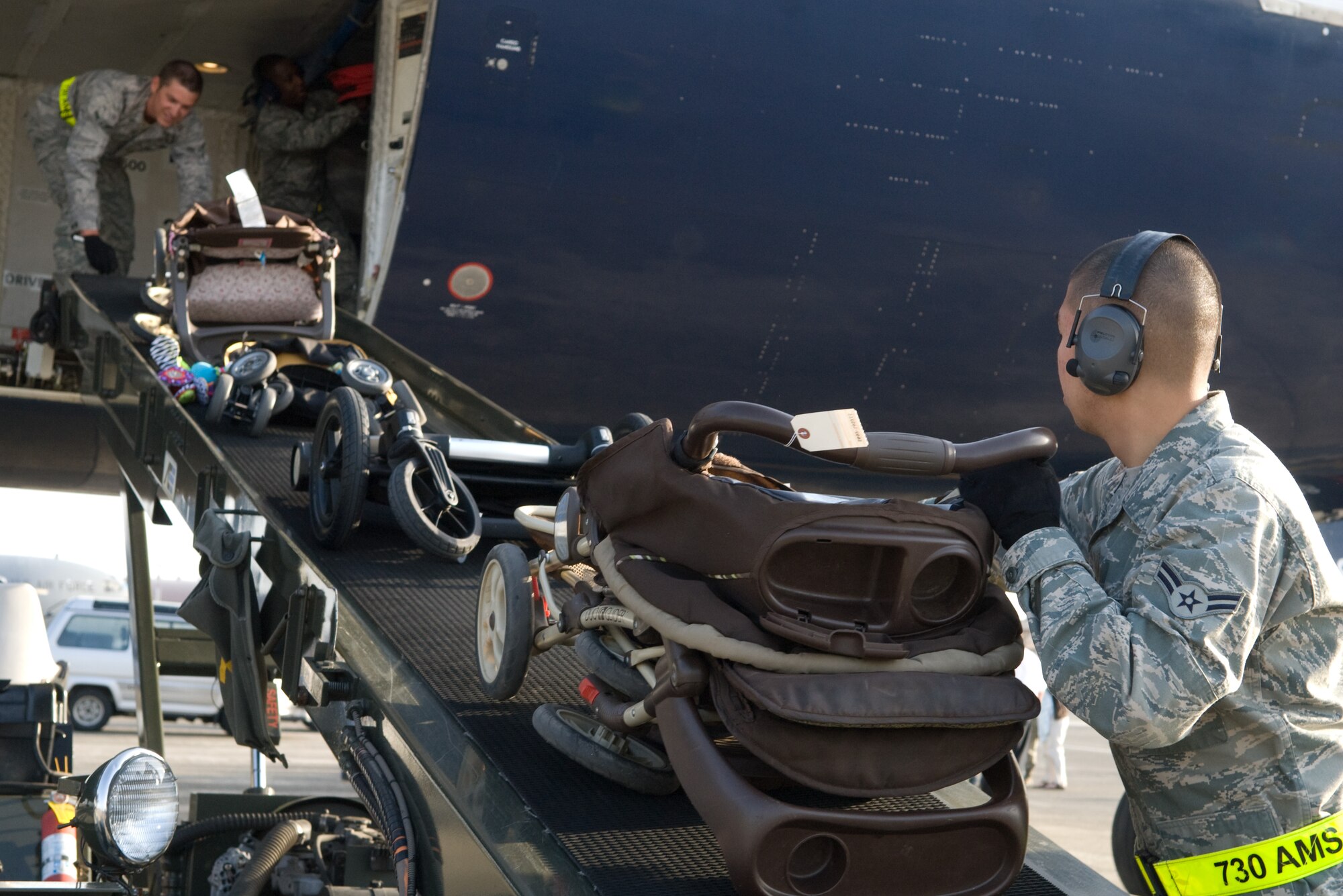 YOKOTA AIR BASE, Japan -- Airmen from the 730th Air Mobility Squadron load strollers on to a Boeing-767 aircraft here March 19. The plane carried 233 passengers as part of the first voluntary authorized departure flight from Yokota. (U.S. Air Force photo/Staff Sgt. Robin Stanchak) 