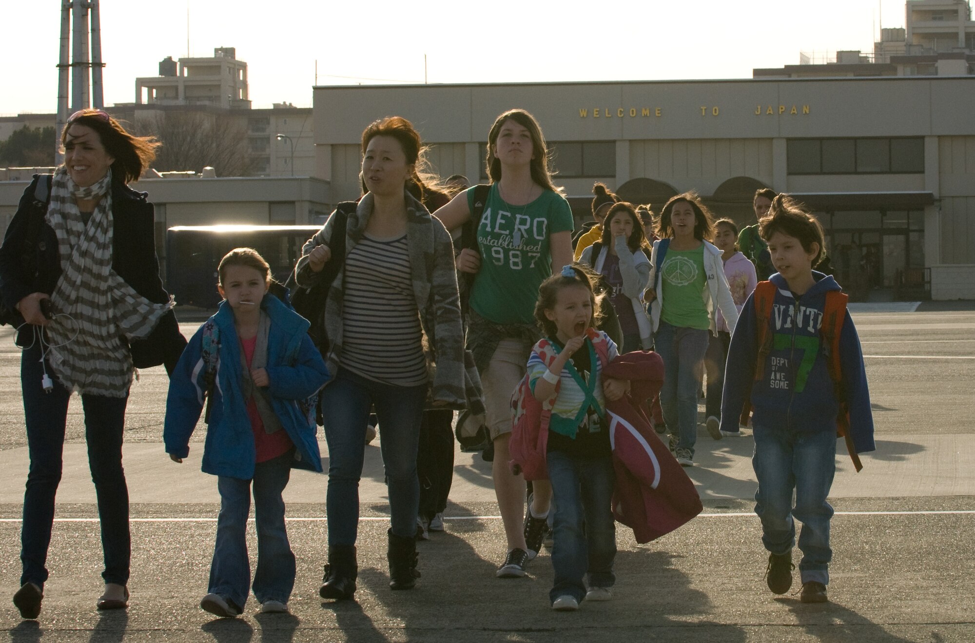 YOKOTA AIR BASE, Japan -- Military family members walk out on the flightline here to board a Boeing-767 flight to Seattle March 19. The aircraft carried 233 passengers on the first voluntary authorized departure flight from Yokota. (U.S. Air Force photo/Staff Sgt. Robin Stanchak) 