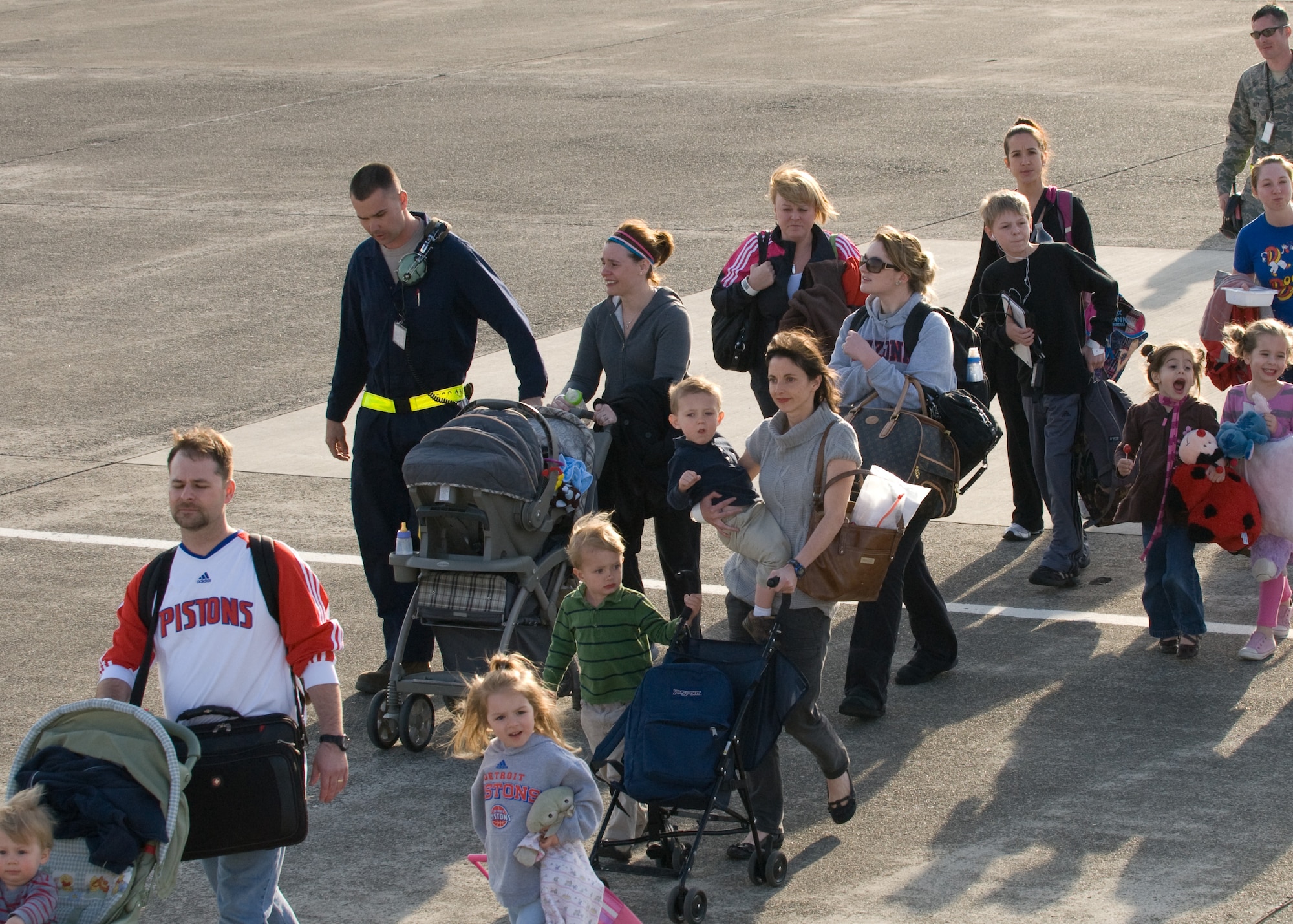 YOKOTA AIR BASE, Japan -- Military family members walk out on the flightline here to board a Boeing-767 flight to Seattle March 19. The aircraft carried 233 passengers on the first voluntary authorized departure flight from Yokota. (U.S. Air Force photo/Staff Sgt. Robin Stanchak) 