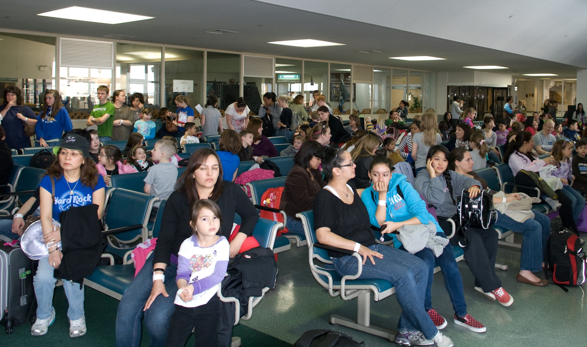 YOKOTA AIR BASE, Japan -- Military family members wait at the passenger terminal here for their flight to Seattle March 19. They are part of the first voluntary authorized departure flight from Yokota. (U.S. Air Force photo/Staff Sgt. Robin Stanchak) 