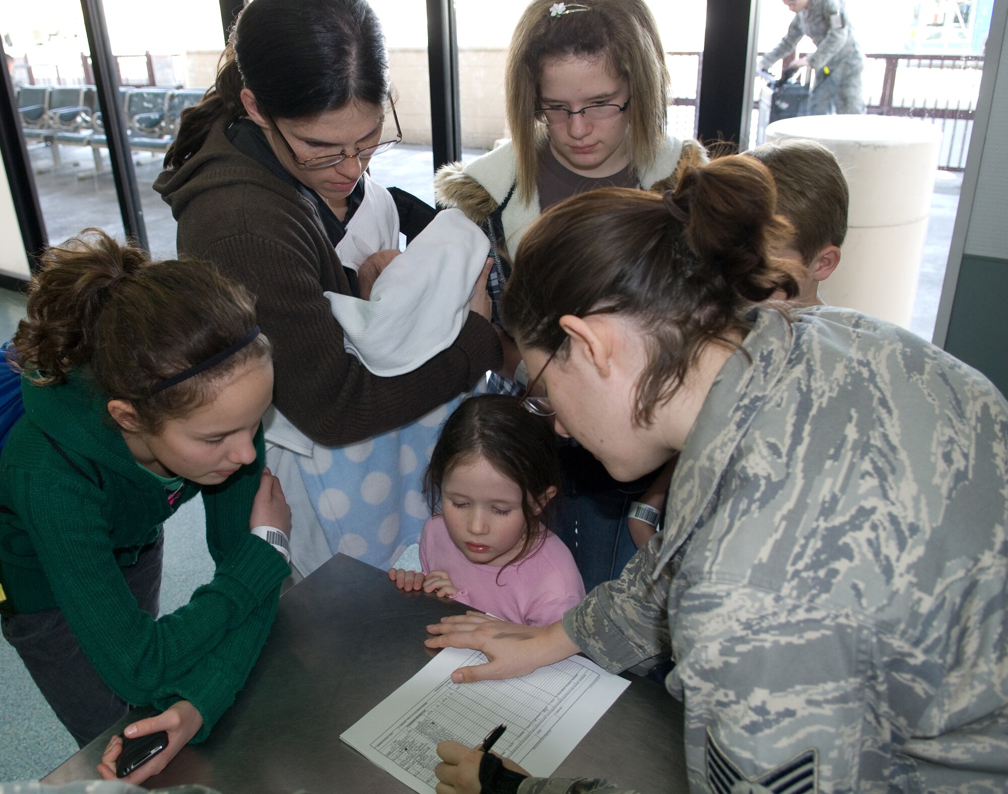 YOKOTA AIR BASE, Japan -- Staff Sgt. Sarah Doroha, 730th Air Mobility Squadron passenger services supervisor, checks family members in at the passenger terminal during the first voluntary authorized departure flight from Yokota March 19. (U.S. Air Force photo/Staff Sgt. Robin Stanchak)
