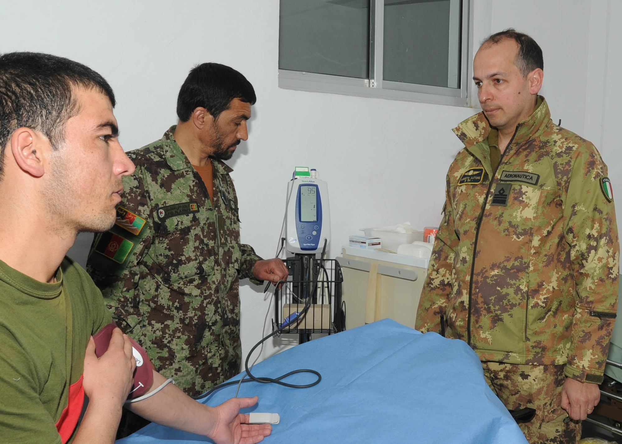 Shindand, Afghanistan - Italian Air Force service member, with NATO Training Mission - Afghanistan / 838th Air Expeditionary Advisory Group, supervises Afghan Air Force doctor at the Afghan clinic in Shindand, Afghanistan. (U.S. Navy photo by Mass Communications Specialist 3rd Class Jared E. Walker).