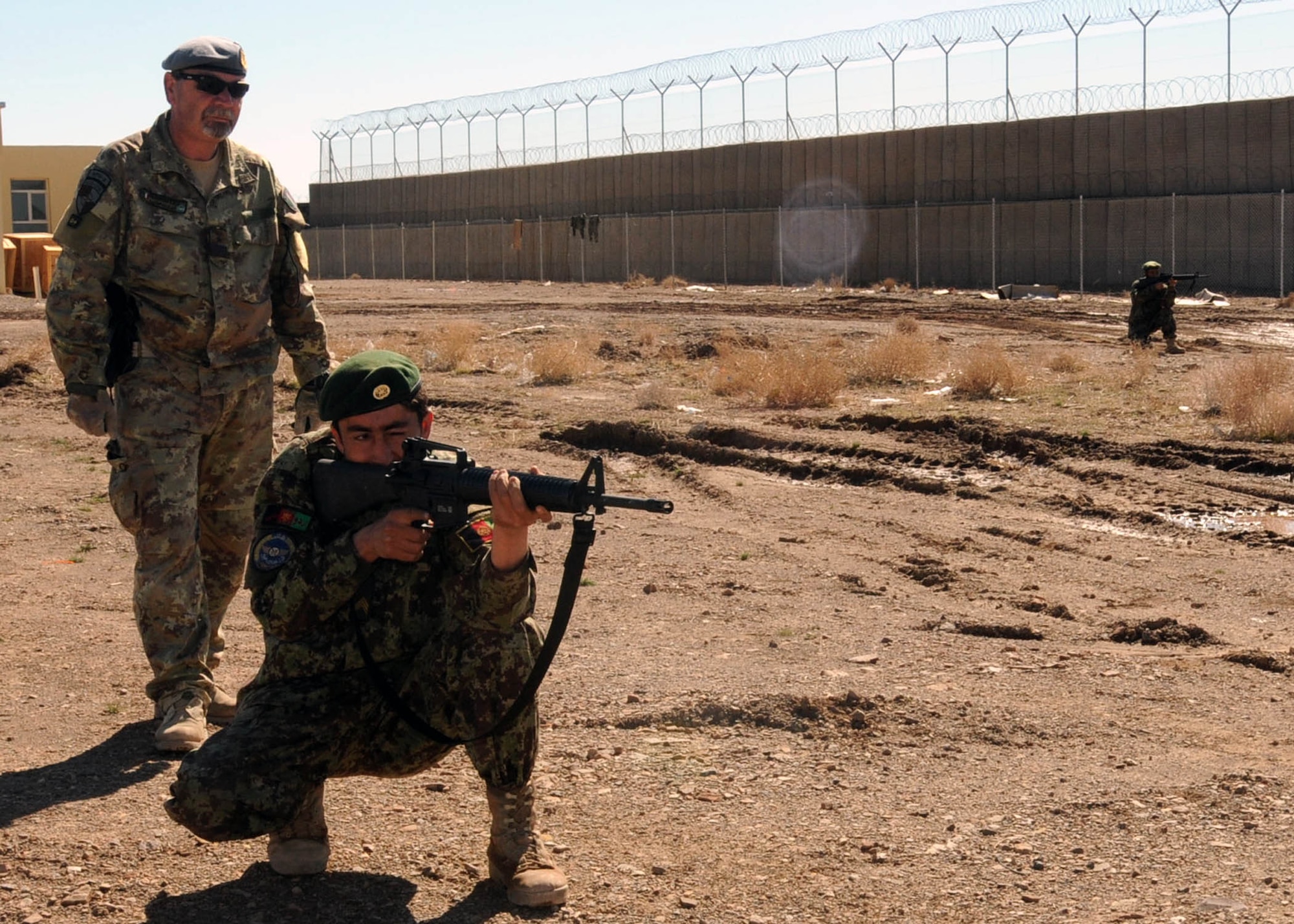 SHINDAND, Afghanistan - Italian Air Force service member, with NATO Training Mission - Afghanistan / 838th Air Expeditionary Advisory Group, supervises a member of the Afghan Air Force security force while the takes part in a security drill in Shindand, Afghanistan. (U.S. Navy photo by Mass Communications Specialist 3rd Class Jared E. Walker).