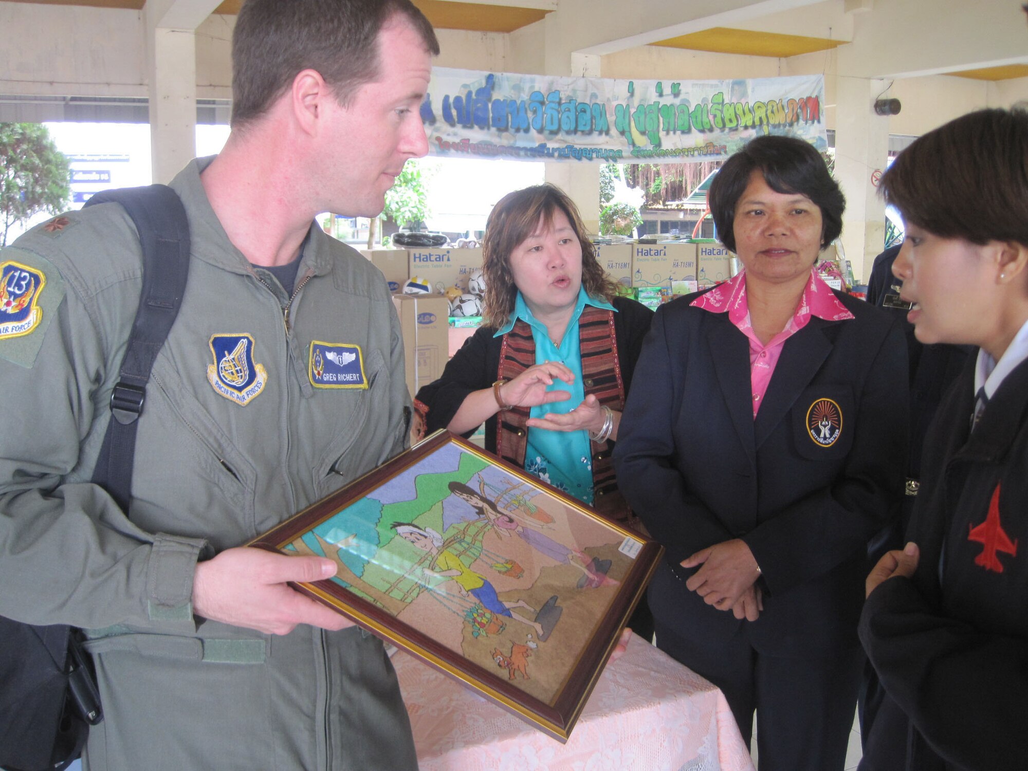 KORAT, Thailand - Maj. Greg Richert accepts a thank you gift on behalf of Cope Tiger Airmen who donation toys and school supplies to the Panyahukul Handicapped School during a community outreach event in Korat, Thailand, March 18.  Major Richert is the Chief of Aerospace Medicine at 13th Air Force, Joint Base Pearl Harbor-Hickam, Hawaii, and medical lead for Exercise Cope Tiger 2011, an annual, multilateral, joint field training exercise currently being conducted at Korat and Udon Thani Royal Thai Air Bases March 14 through 25. (U.S. Air Force Photo/ Capt. Kirsten R. Udd)