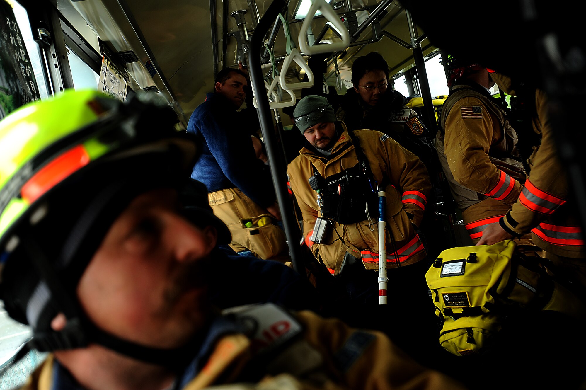 Team members from the Fairfax County, Va. Task Force 1 Urban Search and Rescue ride back to base camp on the bus  after searching structures and debris on March 16, 2011 in Kamaishi, Japan. A 9.0 Earthquake hit Japan on March 11, 2010 that caused a Tsunami that destroyed anything in its path. (U.S. Air Force photo by Master Sgt. Jeremy Lock) (Released)
