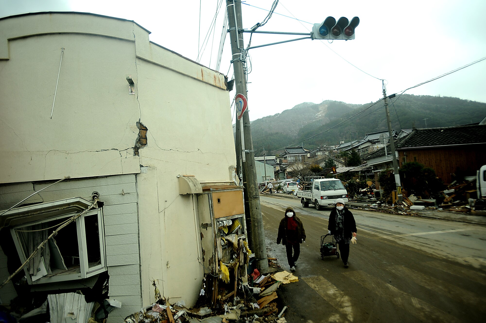 Local Japanese walk the streets that are littered with debris and wreckage that is piled up on March 16, 2011 in Ofunato, Japan. A 9.0 Earthquake hit Japan on March 11, 2010 that caused a Tsunami that destroyed anything in its path. (U.S. Air Force photo by Master Sgt. Jeremy Lock) (Released)
