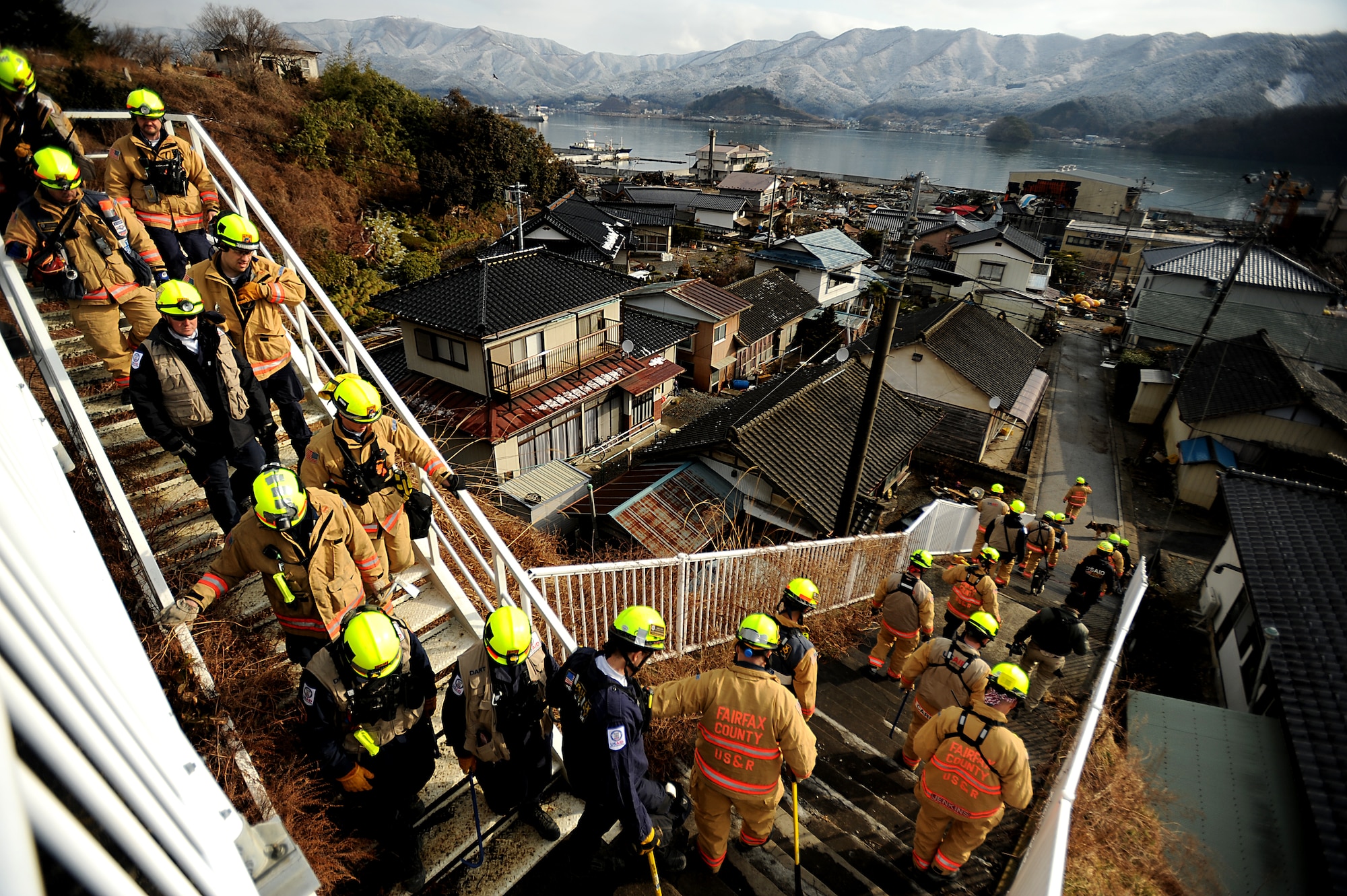 Members of the Fairfax County, Va. Task Force 1 Urban Search and Rescue head down a flight of stairs to start their operations, searching structures and debris on March 16, 2011 in Ofunato, Japan. A 9.0 Earthquake hit Japan on March 11, 2010 that caused a Tsunami that destroyed anything in its path. (U.S. Air Force photo by Master Sgt. Jeremy Lock) (Released)
