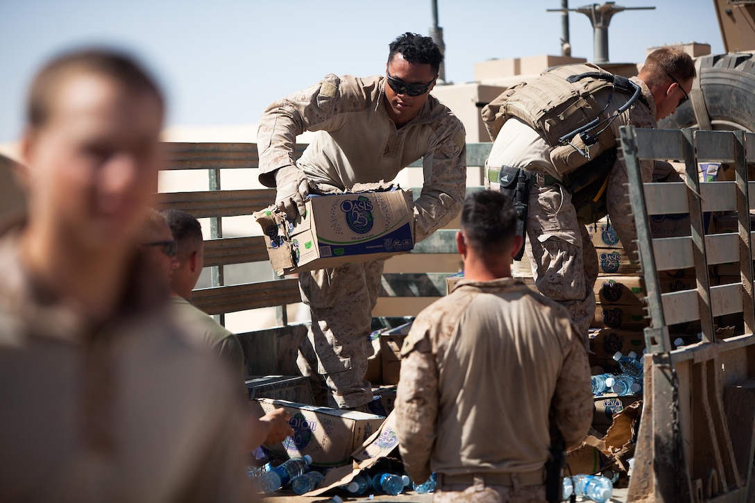 Cpl. Anesone Bentley, a driver for Shaker Mobile, Fox Company, 2nd Battalion, 3rd Marine Regiment, unloads boxes of water at a patrol base in northern Marjah, Helmand province, Afghanistan, March 19.