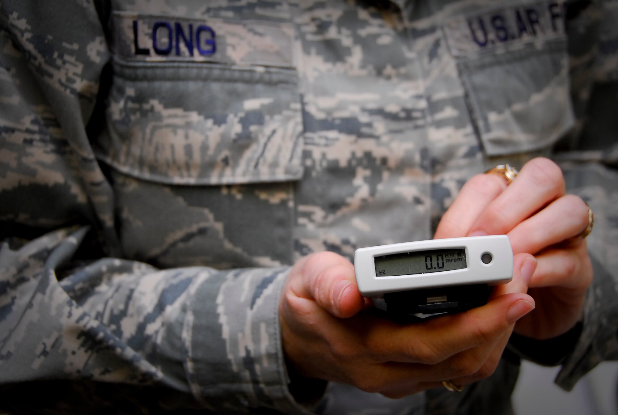 Tech. Sgt. Joanie Long, readiness NCOIC at the 18th Aeromedicine Squadron’s Bioenvironmental Engineering Flight, holds an electronic personal dosimeter at the Bioenvironmental Engineering building, March 15. The dosimeter is one of the many pieces of equipment the two-man crew from 18th AMDS took to mainland Japana for the disaster relief efforts. The team has deploying to Yokota Air Base, near Tokyo, to test for radiation and other possible contaminates in the surrounding environment. (U.S. Air Force photo/Airman 1st Class Maeson L. Elleman)