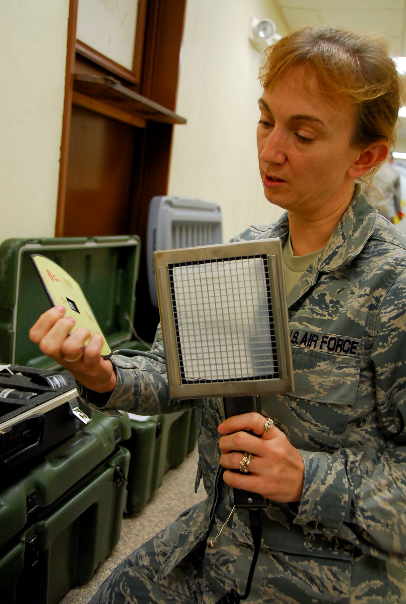 Tech. Sgt. Joanie Long, readiness NCOIC at the 18th Aeromedicine Squadron’s Bioenvironmental Engineering Flight, inspects the equipment that has be taken to mainland Japan, March 15. The two-man team took the equipment to test for radioactive and other harmful chemicals and materials. Amid concerns for the environment, and because Yokota Air Base is 143 miles south of the atomic energy plants that were damaged during the earthquake and tsunami, a two-man team from the 18th AMDS is preparing to assist its sister base. (U.S. Air Force photo/Airman 1st Class Maeson L. Elleman)
