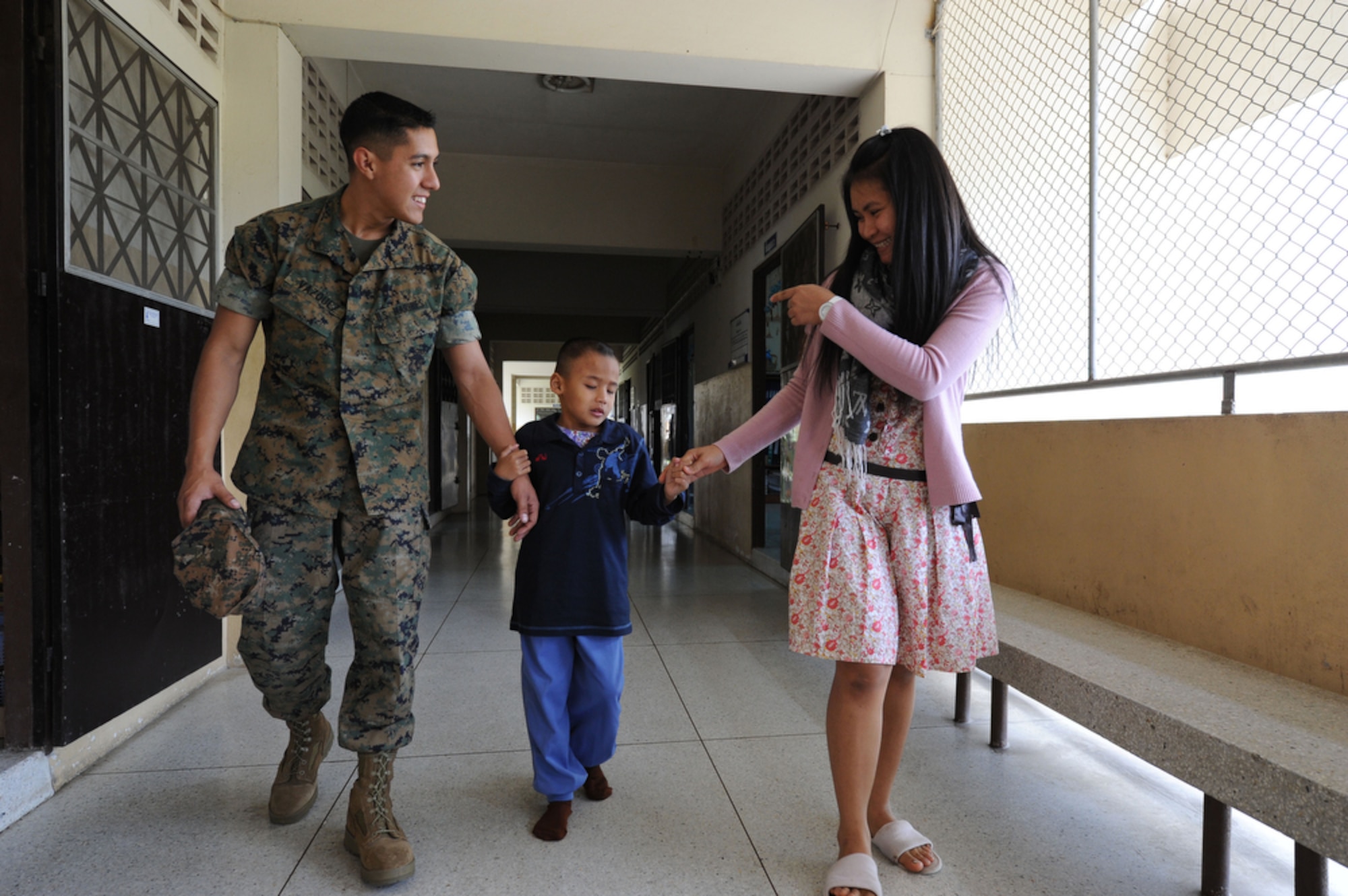 U.S. Marine Lance Corporal Pedro L. Vazquez, Jr., a native of Houston, Texas walks with Darft and his teacher Pim while at the School for the Blind Education Service Center on March 18 in Korat, Thailand, during Cope Tiger 2011,  an annual, multilateral, joint field training exercise currently being conducted at Korat and Udon Thani Royal Thai Air Bases March 14 through 25. Participants of Cope Tiger include the U.S. Air Force, the U.S. Marine Corps, the Royal Thai Air Force, Royal Thai Army, and the Republic of Singapore Air Force. LCPL Vazquez is an aviation mechanic and currently assigned to the Marine All-Weather Fighter Attack Squadron 533, Marine Corps Air Station Iwakuni, Japan. (U.S.  Air Force photo/Master Sgt. Cohen A. Young)