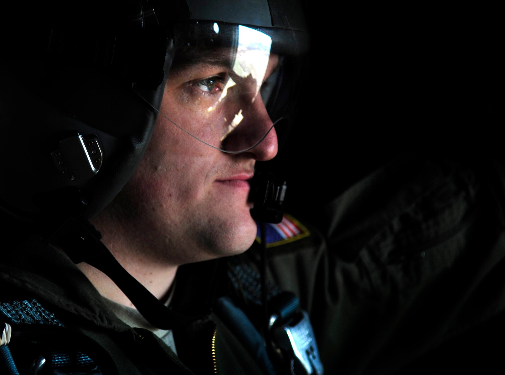 U.S. Air Force Airman 1st Class Austin Koester, 37th Airlift Squadron, load master relays information to pilots of a C-130J, as static line paratroopers prepare to exit for a jump over a landing zone near Campia Turzii, Romania, March 18, 2011.  This jump was conducted as a part of Carpathian Spring 2011, a building partnership capacity exercise where members of U.S. military joined their Romanian counterparts to learn from one another and strengthen alliances. (U.S. Air Force Photo by Tech Sgt. Jocelyn L. Rich)(released)