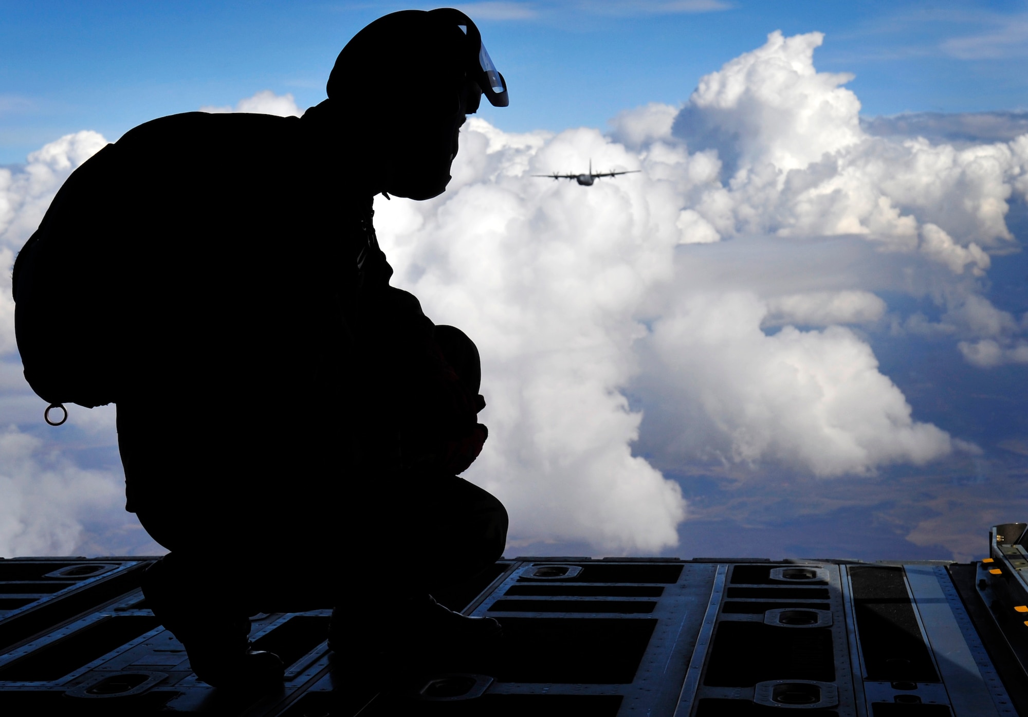 A Romanian Air Force High Altitude, Low Open (HALO) paratrooper, awaits his signal to jump out of a U.S. Air Force C-130J during a combined HALO jump over a landing zone near Campia Turzii, Romania, March 18, 2011.  This jump was conducted as a part of Carpathian Spring 2011, a building partnership capacity exercise where members of U.S. military joined their Romanian counterparts to learn from one another and strengthen alliances. (U.S. Air Force Photo by Tech Sgt. Jocelyn L. Rich)(released)