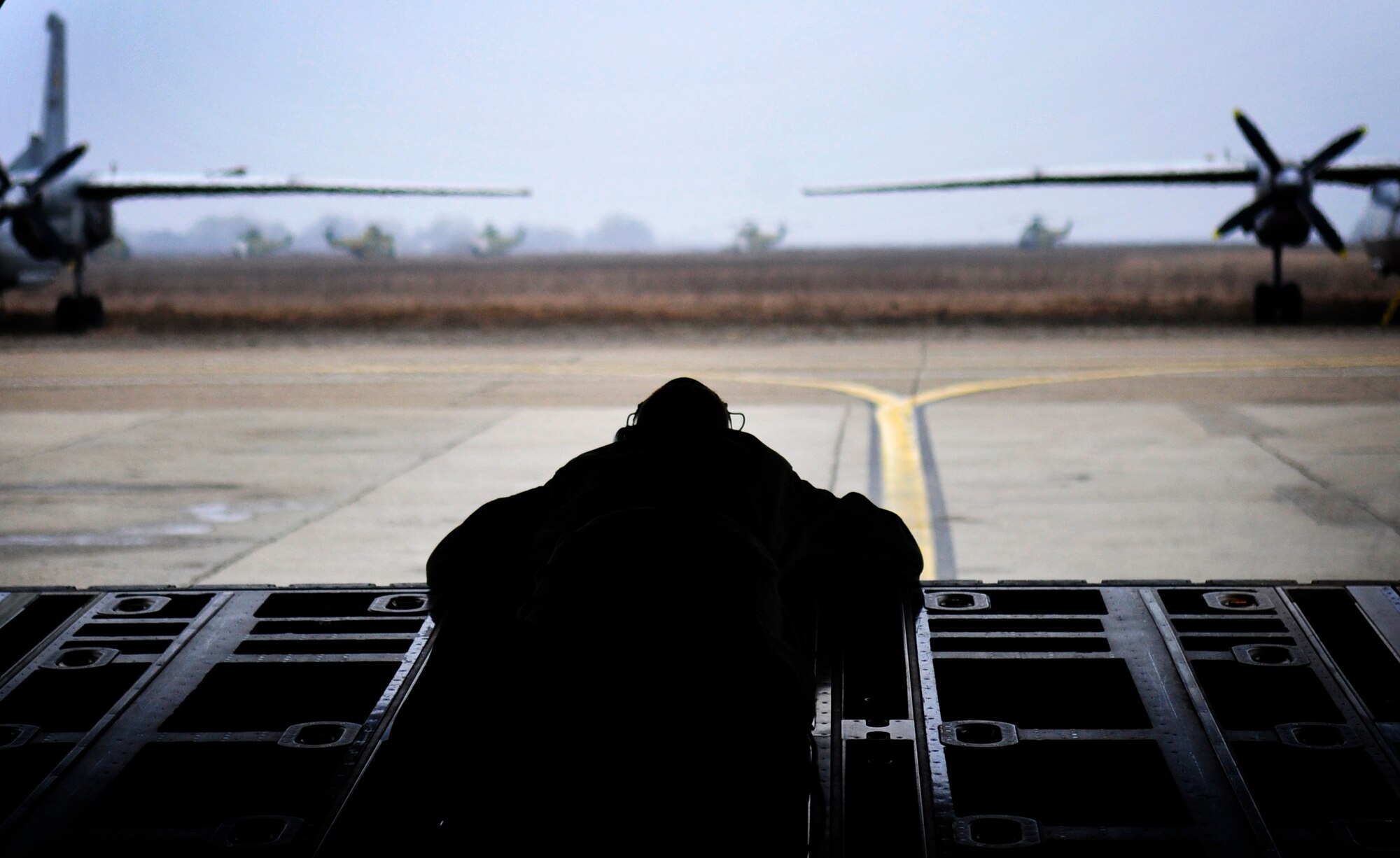 U.S. Air Force Airman 1st Class Austin Koester, 37th Airlift Squadron, loadmaster, assists in that taxi of a C-130J, at Airlift Base Otopeni, Romania, March 18, 2011. The C-130J is taking off to take part in a training mission during Carpathian Spring 2011, a building partnership capacity exercise where members of U.S. military joined their Romanian counterparts to learn from one another and strengthen alliances. (U.S. Air Force Photo by Tech Sgt. Jocelyn L. Rich)(released)