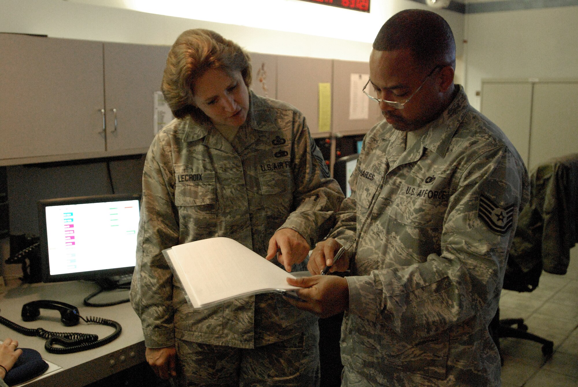 Senior Master Sgt. LeaAnne LeCroix and Tech. Sgt. Ervin Charles, both 433rd Airlift Wing Command Post, go over some statistics. The 433rd command post acts as the wing's nerve center for information and operations.  The Alamo Wing command post was named the 4th Air Force Small Conventional Command Post of the Year and is in competition for the Air Force Reserve Command award. (U.S. Air Force photo/Senior Airman Brian McGloin)