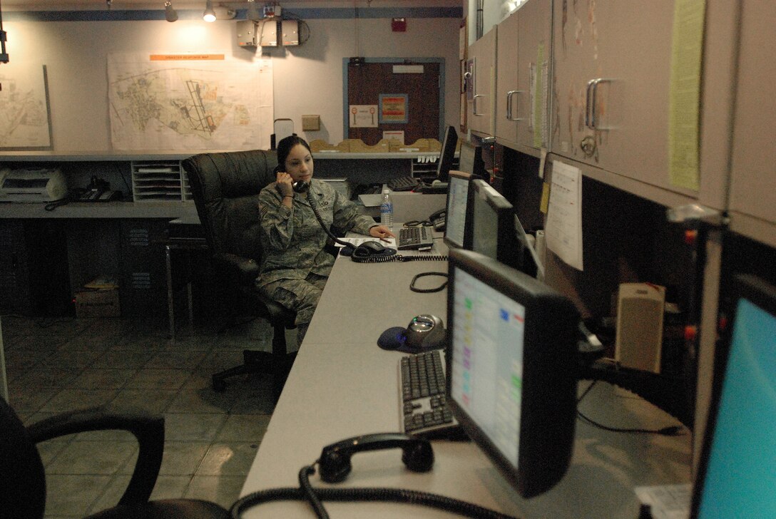 Staff Sgt. Jenny Sanchez answers questions about flight plans in the wing's nerve center for information and operations, the 433rd Airlift Wing command post. The Alamo Wing command post was named the 4th Air Force Small Conventional Command Post of the Year and is in competition for the Air Force Reserve Command award. (U.S. Air Force photo/Senior Airman Brian McGloin)