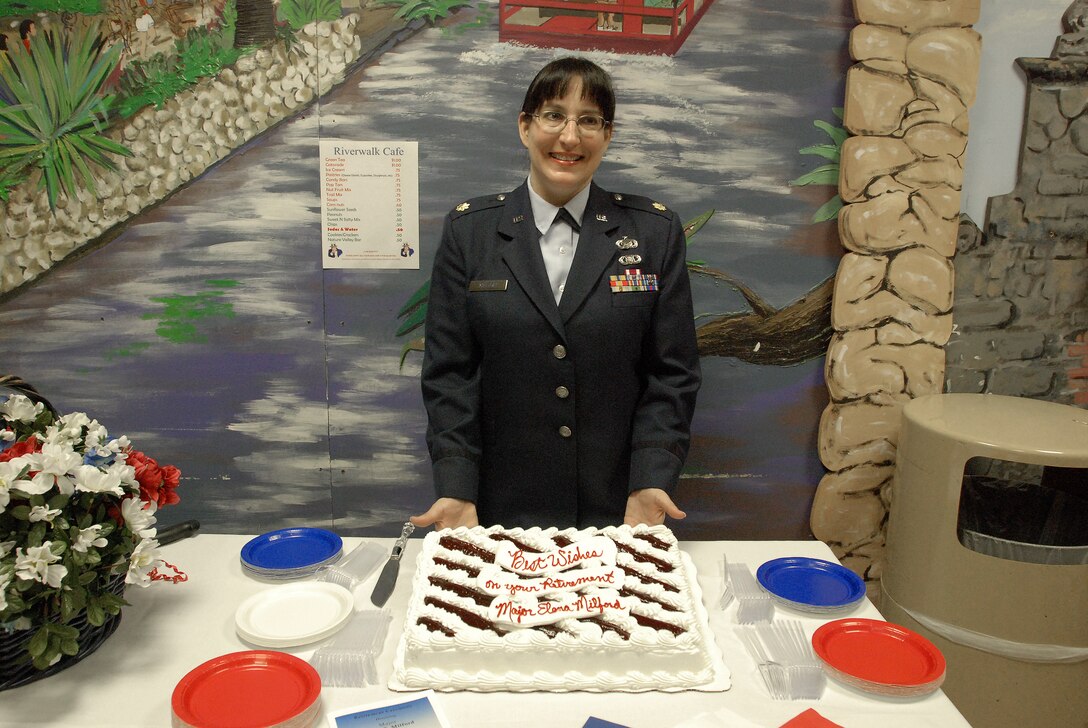 Maj. Elena Milford, 433rd Airlift Wing Public Affairs chief prepares to serve cake after her retirement ceremony in the 68th Airlift Squadron auditorium, Lackland Air Force Base, Texas. (U.S. Air Force photo/Senior Airman Brian McGloin)