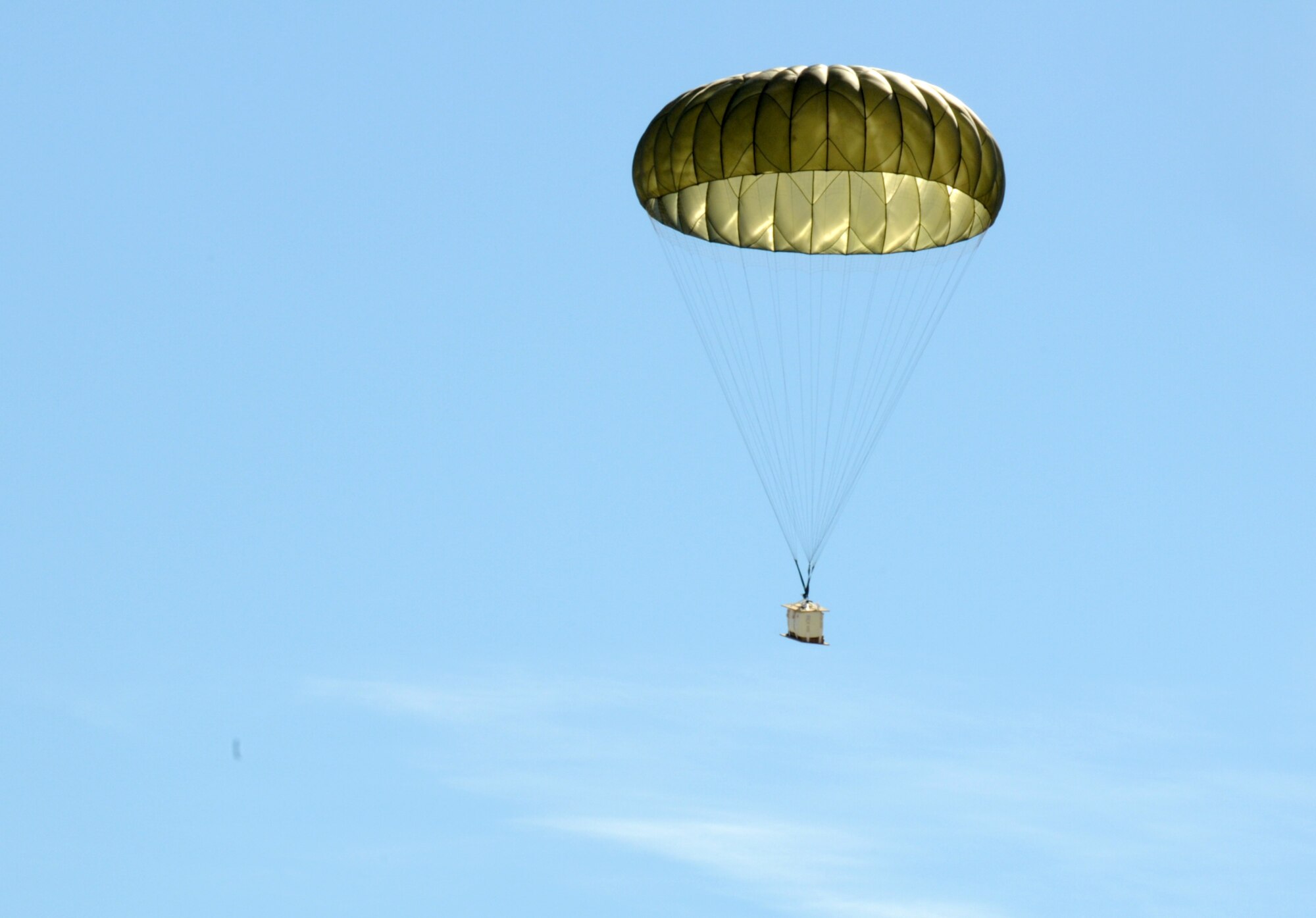 A Low Cost Low Altitude pratice load swings beneith a full parachute canopy in the blue skys of the California desert March 2, 2011 after falling from a 133rd Airlift Wing C-130 Hercules.During the week of February 28th, 2011 Airmen and the C-130 Hercules of the 133rd Airlift Wing, Minnesota Air National Guard deployed for training to Yuma Proving Ground, Yuma Arizona. During the week the 133rd AW practiced Low-Cost Low-Altitude airdrops this knowledge and experience will be directly applied during deployment to Afganistan. The LCLA bundles are more accurate and use expendable parachutes weighing in at 80 to 500 pounds. LCLA is well suited for small units on patrol or in remote outposts where they don't have the equipment or manpower to deal with the larger container delivery system bundles. U.S. Air Force photo by Tech. Sgt. Erik Gudmundson