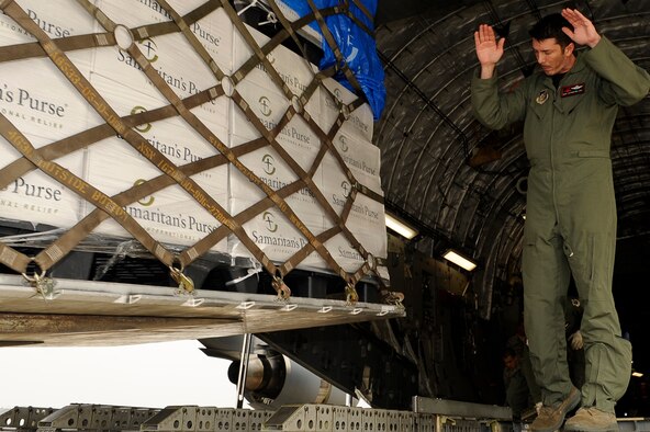 Master Sgt. Stephen Mallory, C-17 Globemaster III loadmaster from the 517th Airlift Squadron at Joint Base Elemendorf-Richardson, Alaska, directs the unloading of humanitarian supplies at Sendai Airport, Japan, on March 20, 2011, in support of Operation Tomodachi. Sergeant Mallory and crew members from the 517th AS flew the first C-17 mission to Sendai Airport following the 8.9-magnitude earthquake and subsequent tsunami that struck the area March 11, 2011 (U.S. Air Force Photo/Master Sgt. Jeromy K. Cross)
