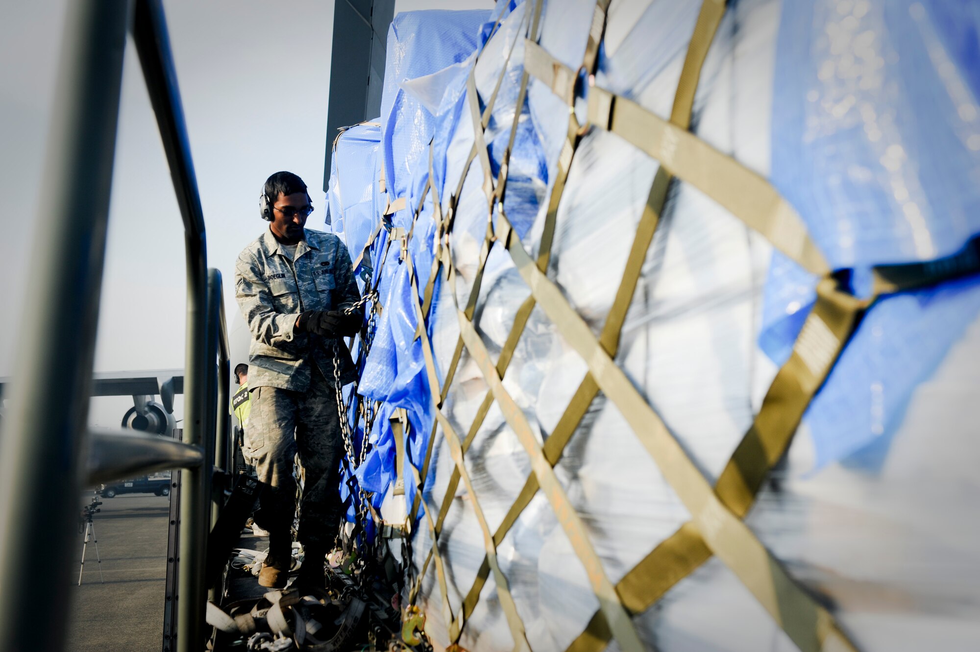 YOKOTA AIR BASE, Japan -- Airman 1st Class Hayden Boeglin, 730th Air Mobility Squadron, strips off a chain from supplies to be loaded onto a C-17 Globemaster III March 20. The supplies were delivered to Sendai Airport to be used for humanitarian assistance bringing relief to Japan from the earthquake and tsunami disaster. (U.S. Air Force photo/Staff Sgt. Jonathan Steffen)
